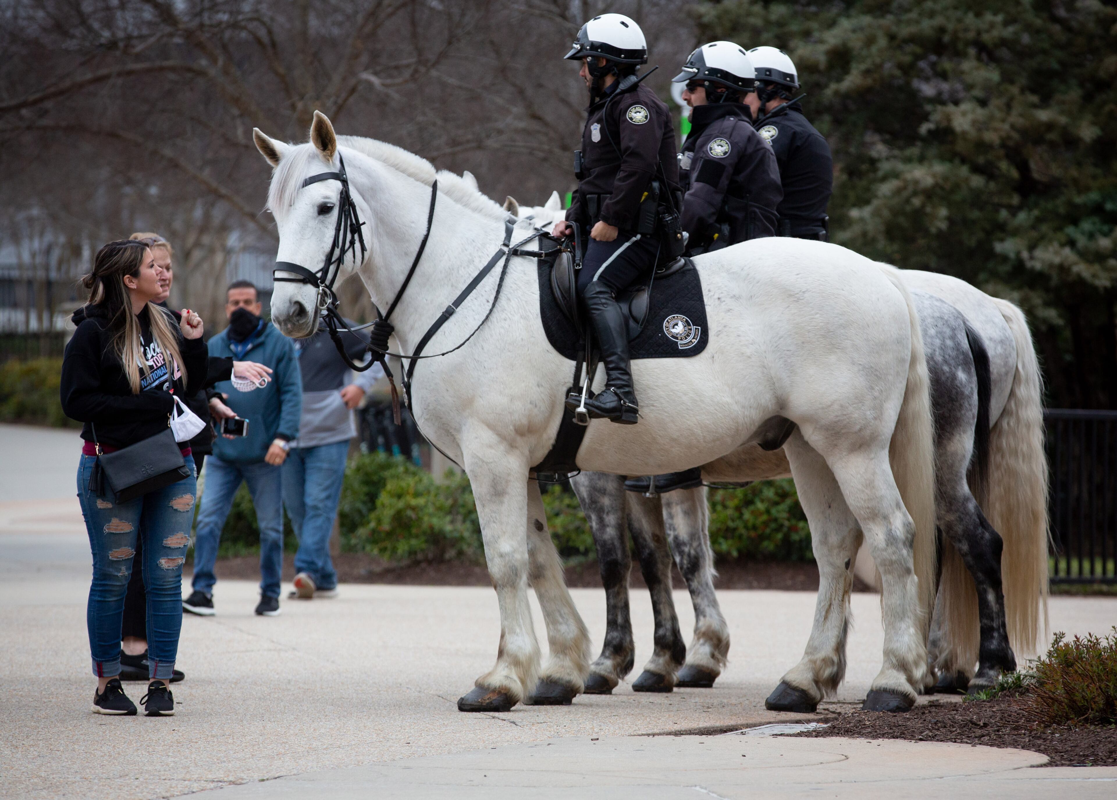 People look over the Atlanta Police Mounted Patrol horses near the Georgia Aquarium on Saturday, March 6, 2021. (Photo: Steve Schaefer for The Atlanta Journal-Constitution)