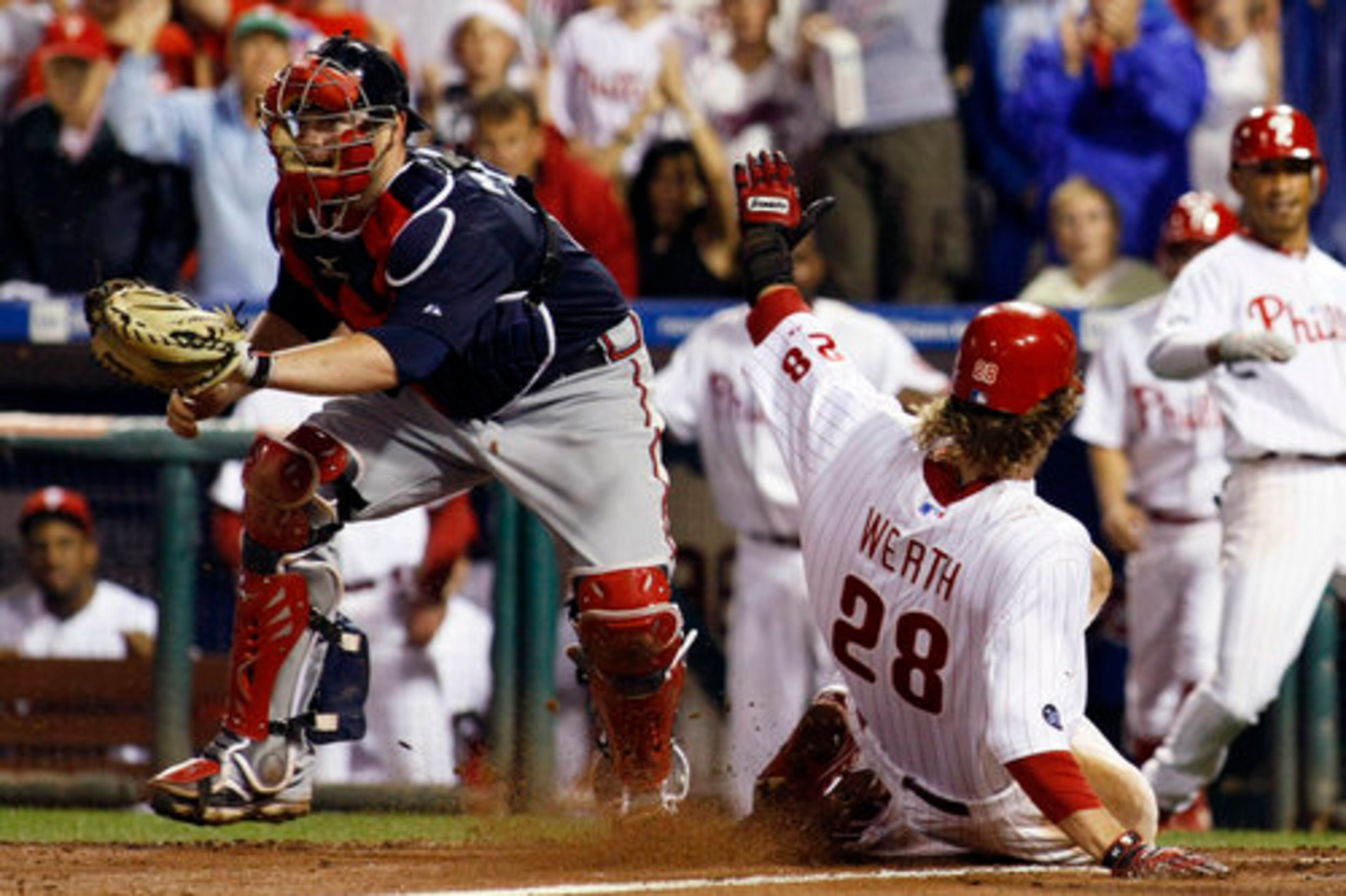 Philadelphia Phillies' Jayson Werth, right, slides past Atlanta Braves catcher Brian McCann to score on an RBI double by Raul Ibanez in the eighth inning of a baseball game, Wednesday, Sept. 22, 2010, in Philadelphia.
