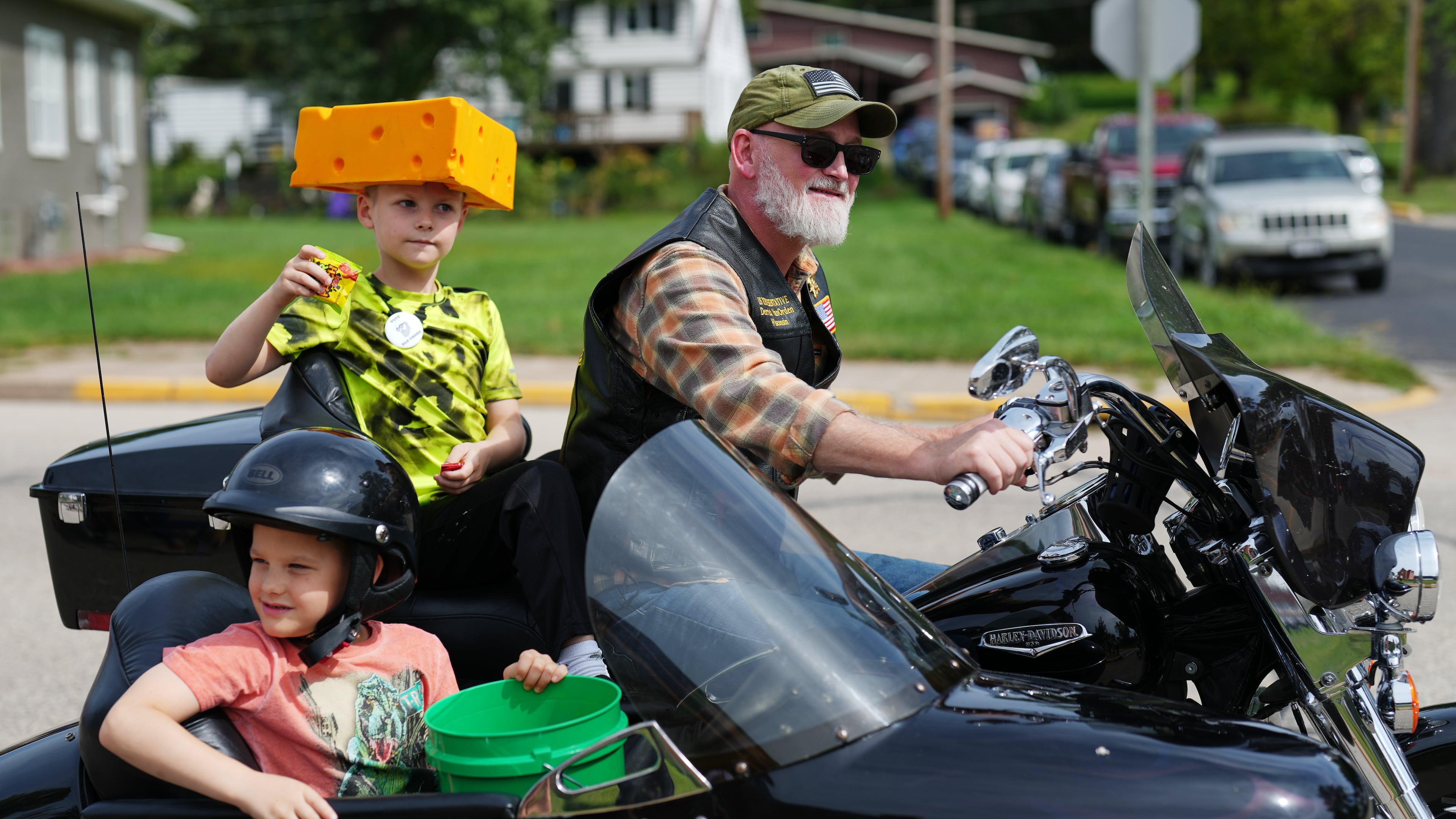 U.S. Rep. Derrick Van Orden rides his motorcycle in a Labor Day parade with his grandsons, Teddy and Henry, Monday, Sept. 7, 2026, in Readstown, Wis. (AP Photo/Ellen Schmidt)