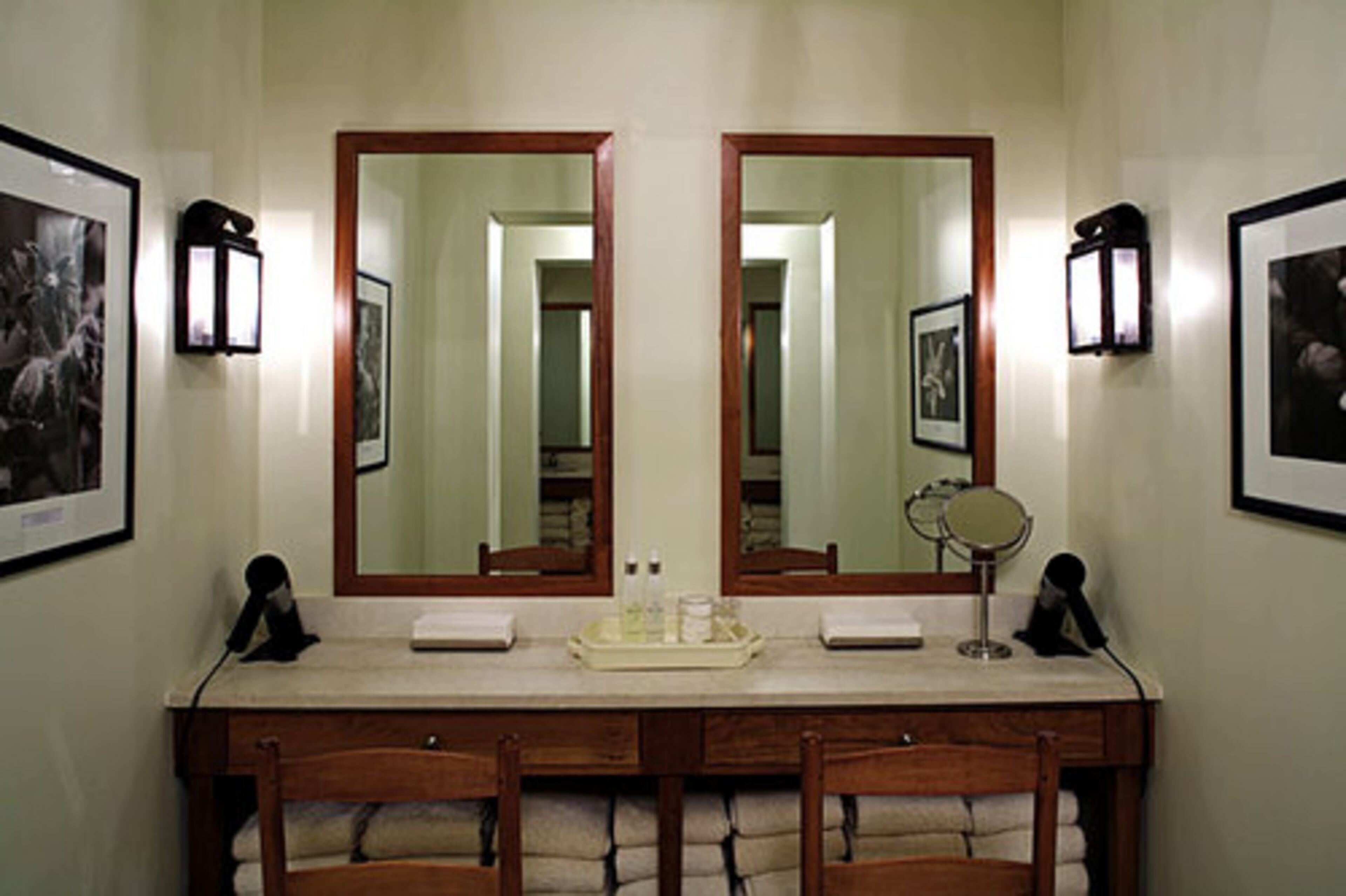 Cherry furnishings, handcrafted metal light fixtures and photographs of historic Virginia gardens adorn the vanity area in the women's locker room.