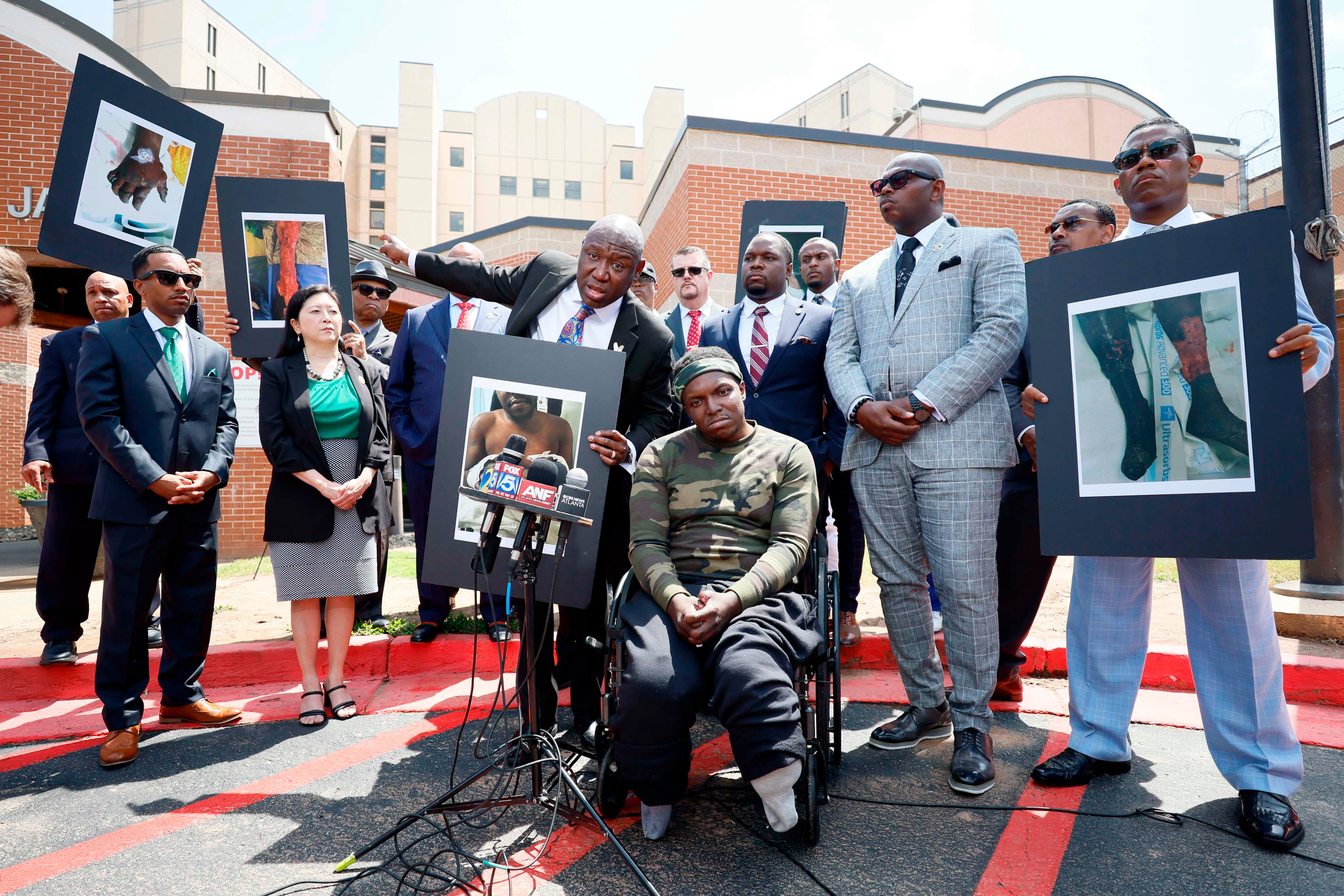 Civil rights attorney Ben Crump (center left), his legal team and other supporters of Rashaad Muhammad (seated) speak to reporters outside the Fulton County Jail on Wednesday. (Miguel Martinez/AJC)