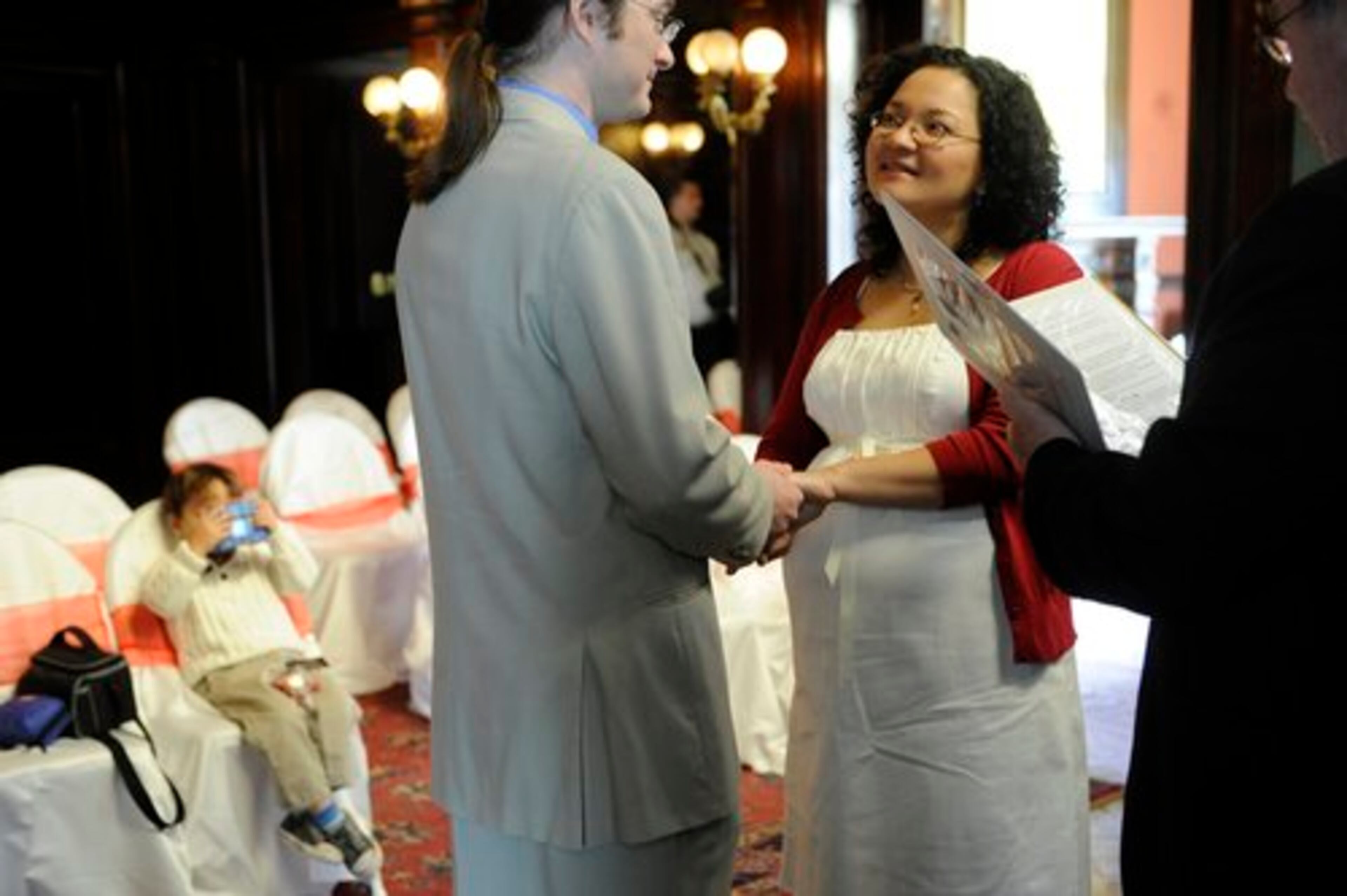 Aaron Cobb and Jamie Ravenscraft renew their vows with son Zeke, 3, watching from his seat on Valentine's Day at Rhodes Hall in Atlanta. The couple married in North Carolina 10 years ago and wanted to renew their vows after reading about Cupid at the Castle last year.