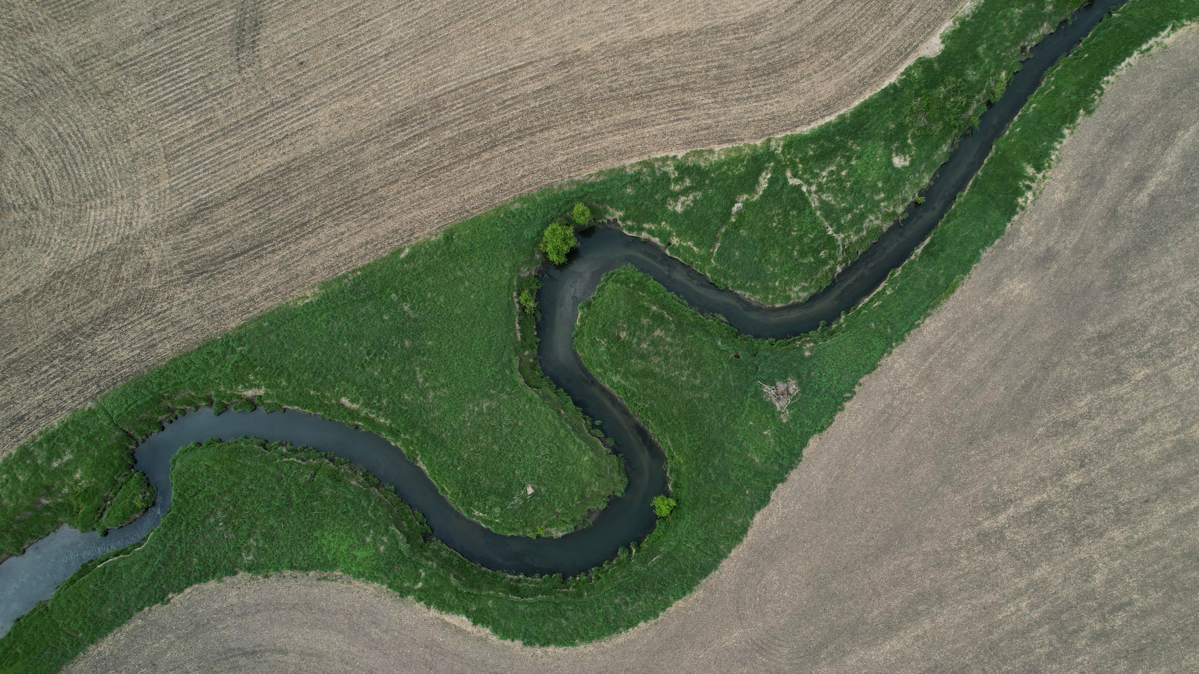 FILE - A stream cuts through a farm field, May 7, 2026, near Marshalltown, Iowa. (AP Photo/Brittany Peterson, File)