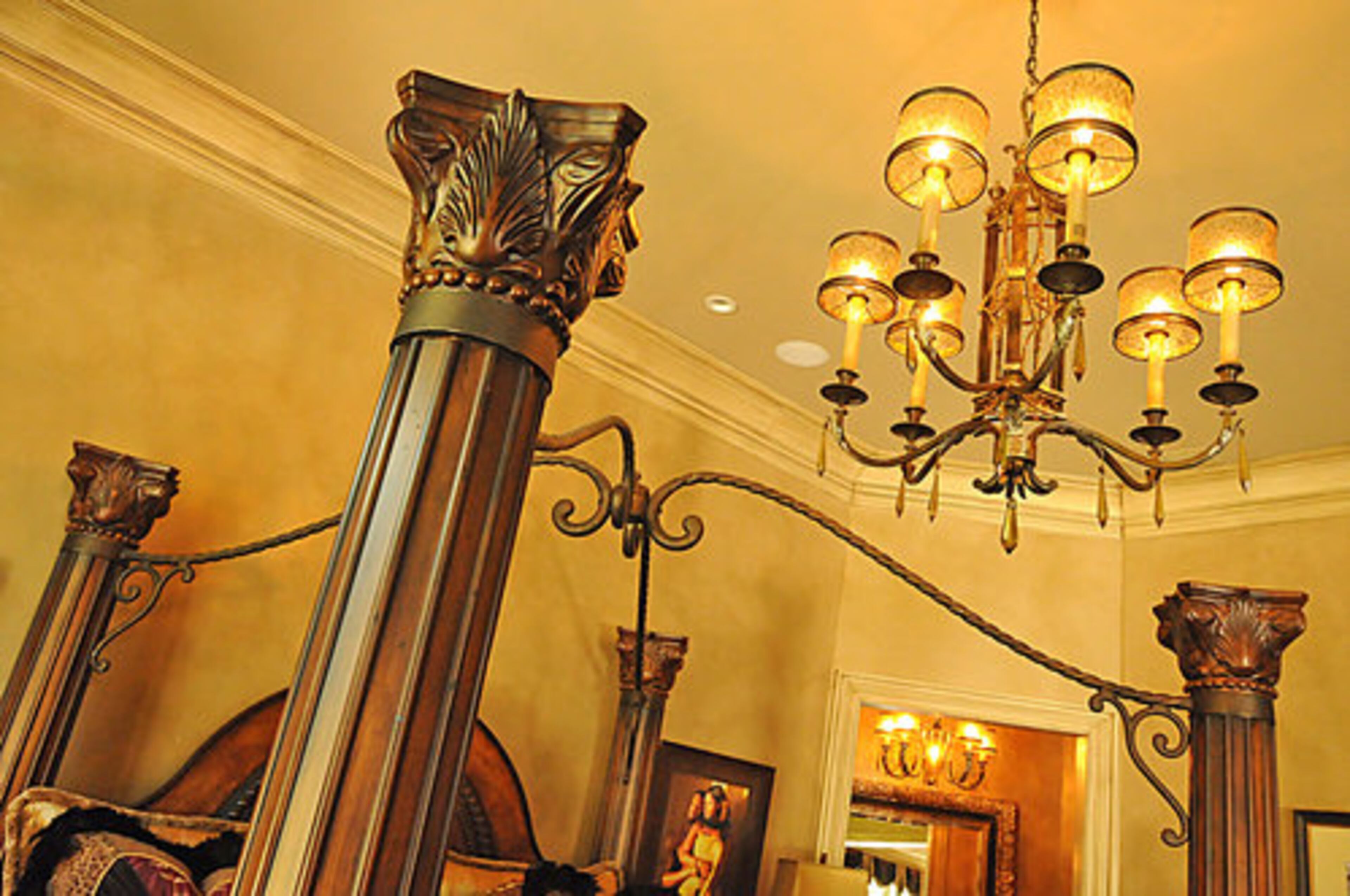 Closeup of the bed frame which features four stately columns with a decorative overhead frame.