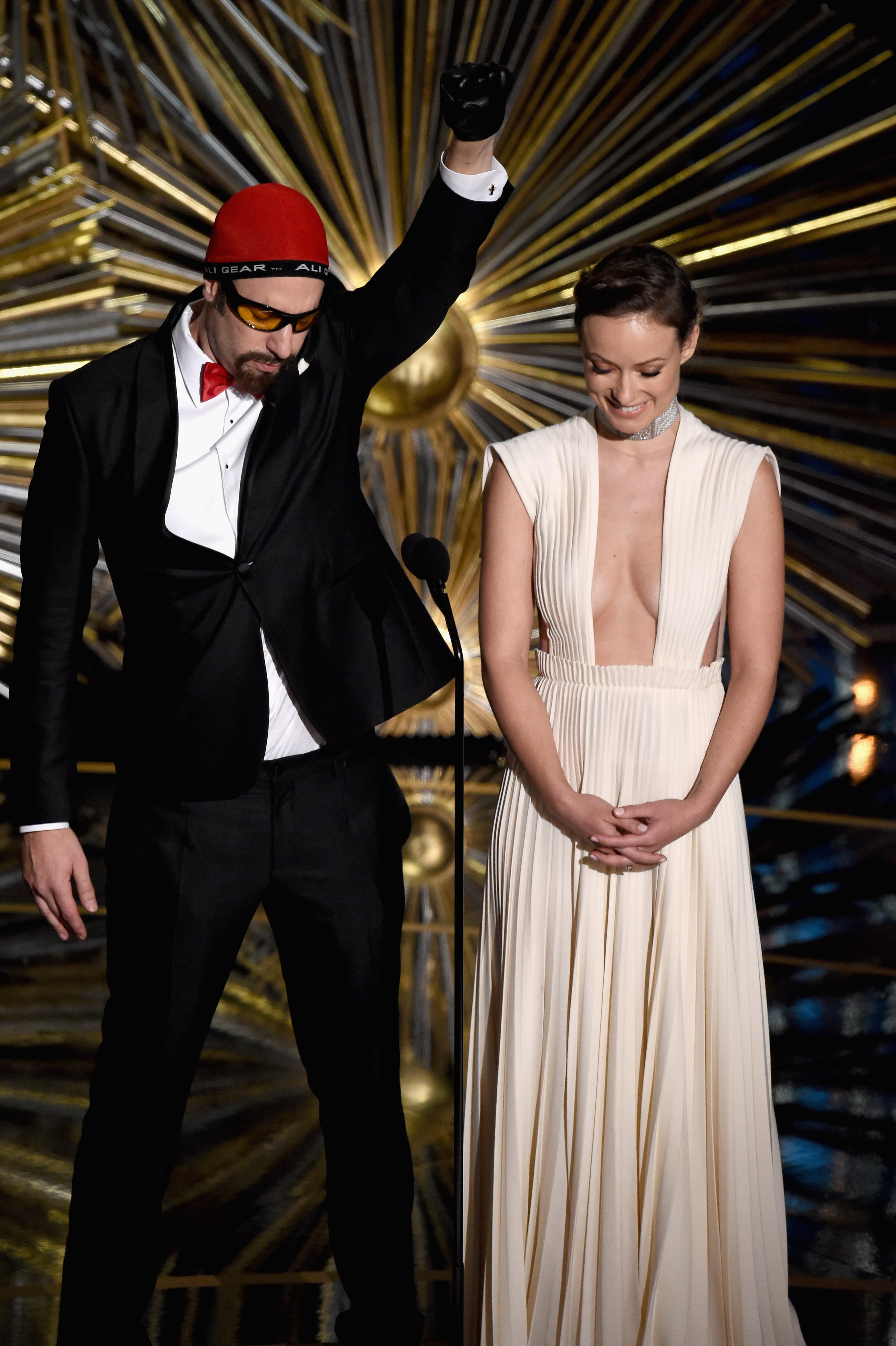 HOLLYWOOD, CA - FEBRUARY 28: Actors Sacha Baron Cohen (L) and Olivia Wilde speak onstage during the 88th Annual Academy Awards at the Dolby Theatre on February 28, 2016 in Hollywood, California. (Photo by Kevin Winter/Getty Images)