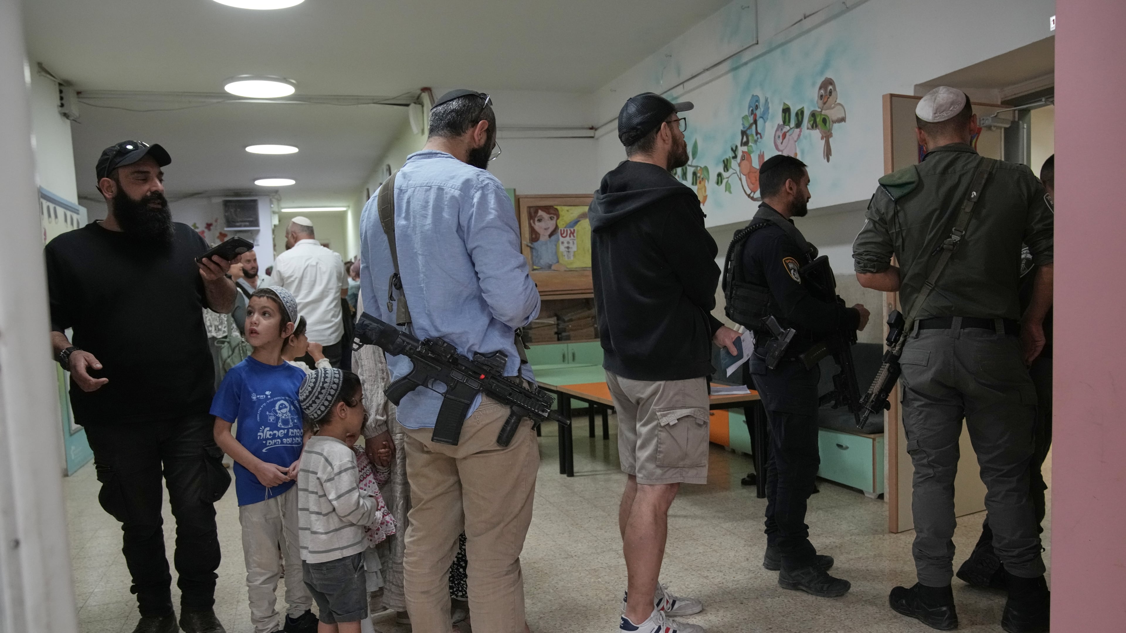 Israeli settlers line up to vote at a school serving as a polling station during Israel's general election in the settlement of Kiryat Arba, in the occupied West Bank, Tuesday, Oct. 27, 2026. (AP Photo/Leo Correa)