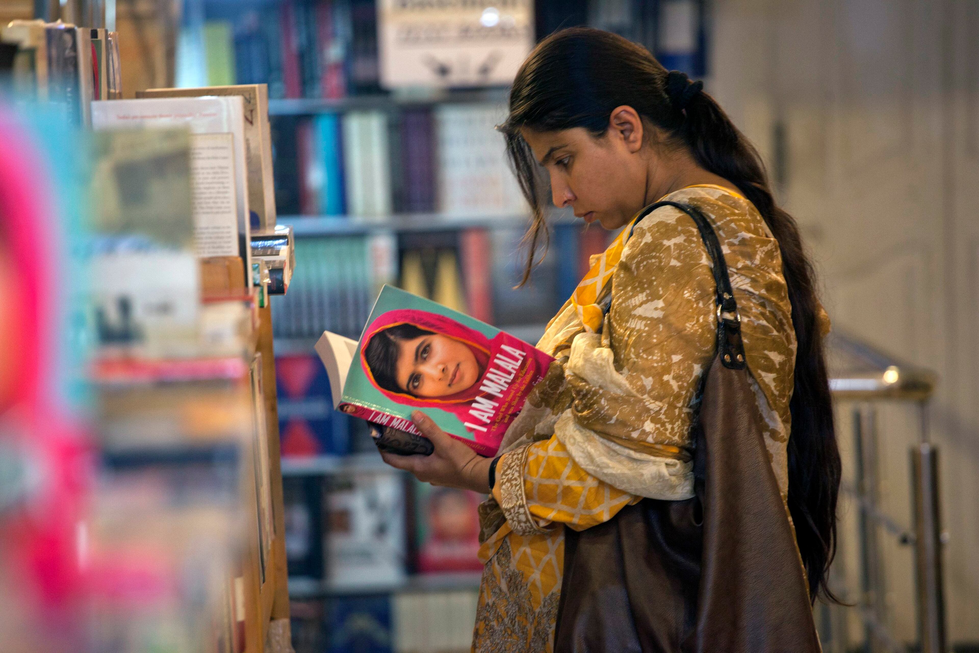 A woman browses a copy of Malala Yousufzai's book "I am Malala" at a book store in Islamabad October 8, 2013.