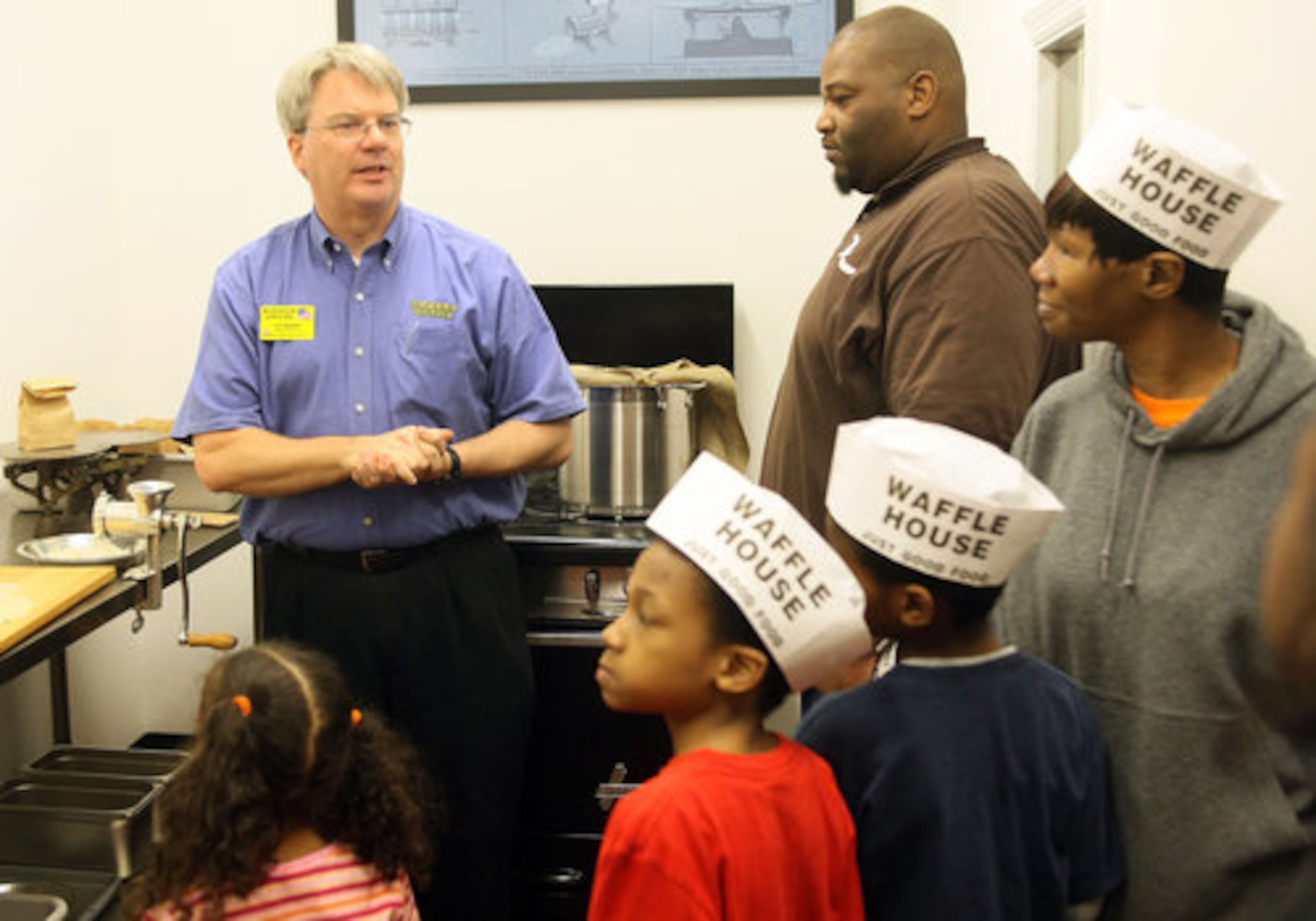 Pat Warner (left) gives a tour of the original kitchen at the Waffle House.