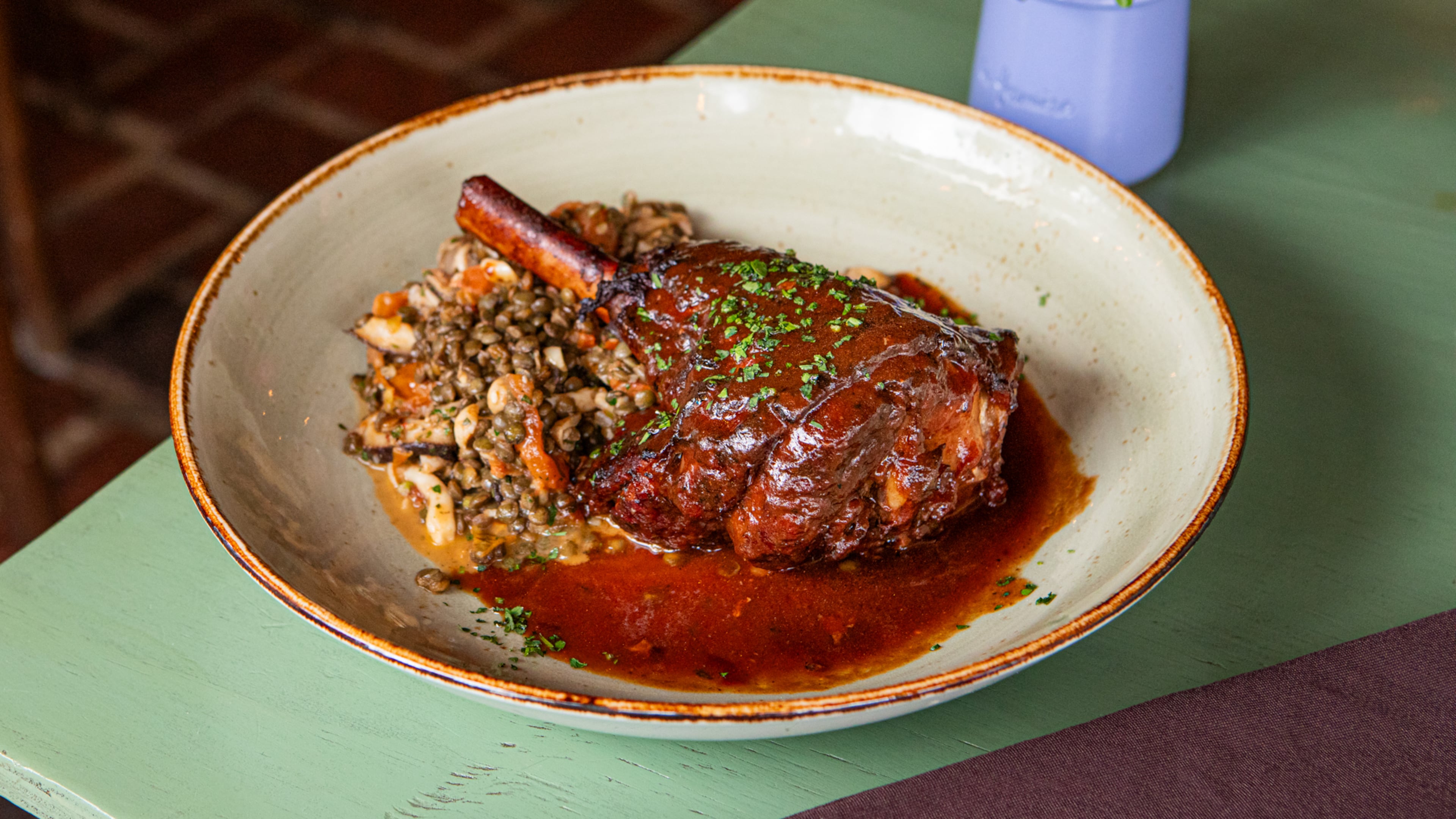 Chef Derek Larsen's braised lamb shank, called Jarret D'Agneau Braise, is on the menu at Anis Cafe & Bistro. (Aaliyah Man for The Atlanta Journal-Constitution / Food styling by Derek Larsen)