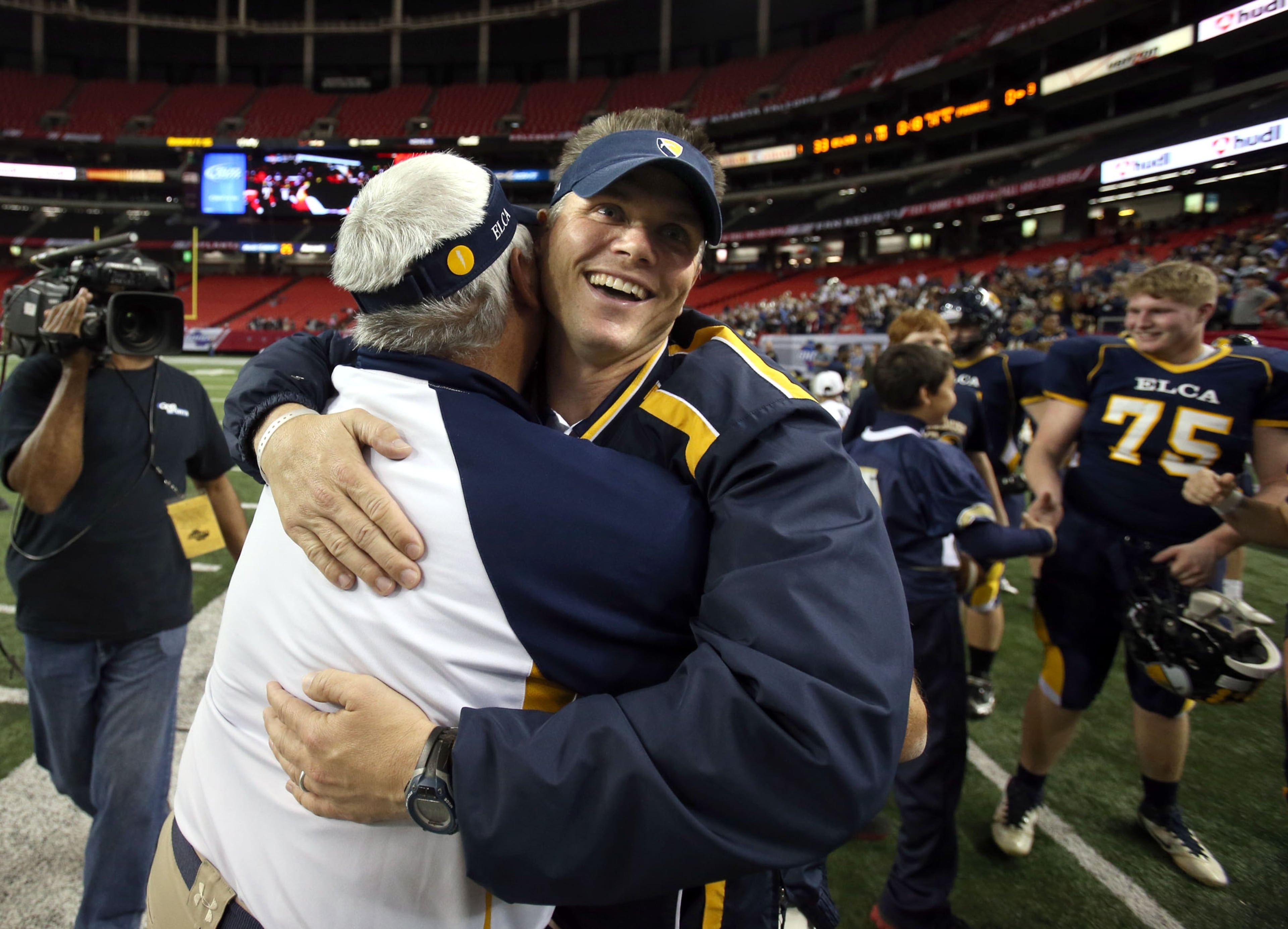 Eagle's Landing Christian Academy coach Jonathan Gess receives a hug after the 2012 Class A private-school championship game, a 33-0 victory over Prince Avenue Christian. It was the first of six state titles for Gess and ELCA. (Jason Getz/AJC)