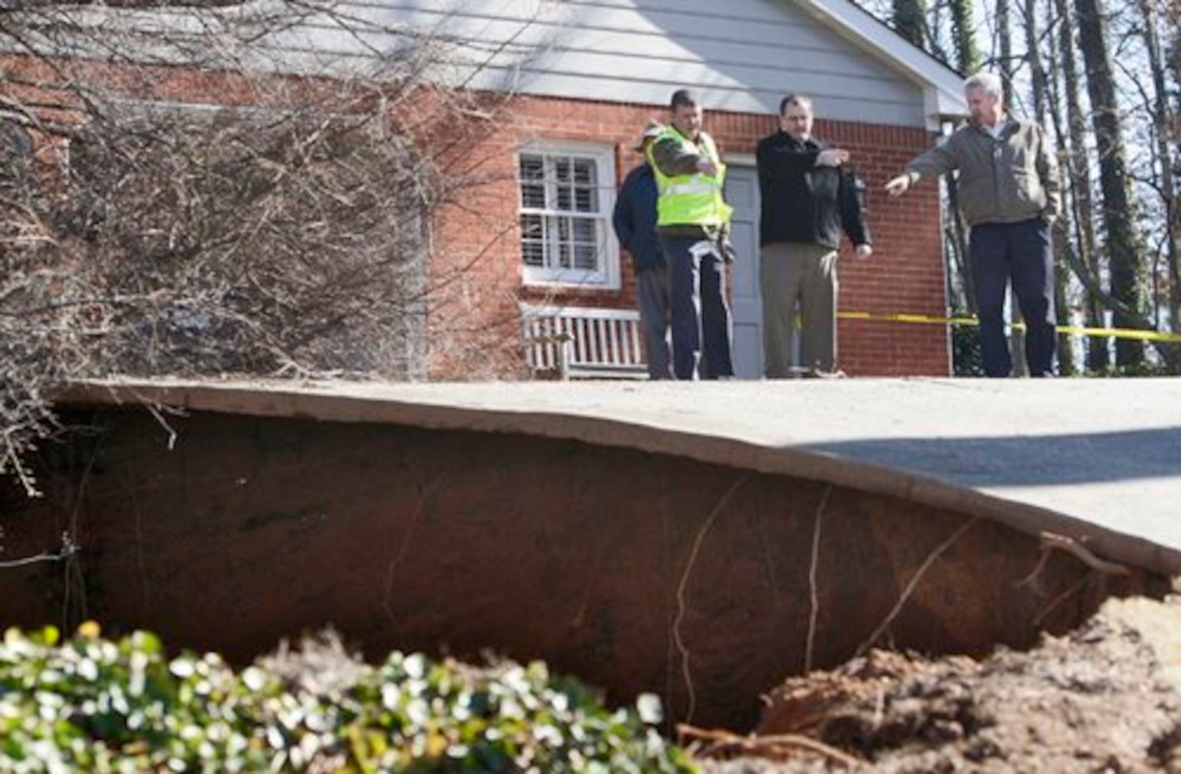 Consultant Louis Babler (from left), Marietta's director of public works Dan Conn, and city engineer Jim Wilgus survey the opening, which was first believed to be "an old mine exploration shaft."