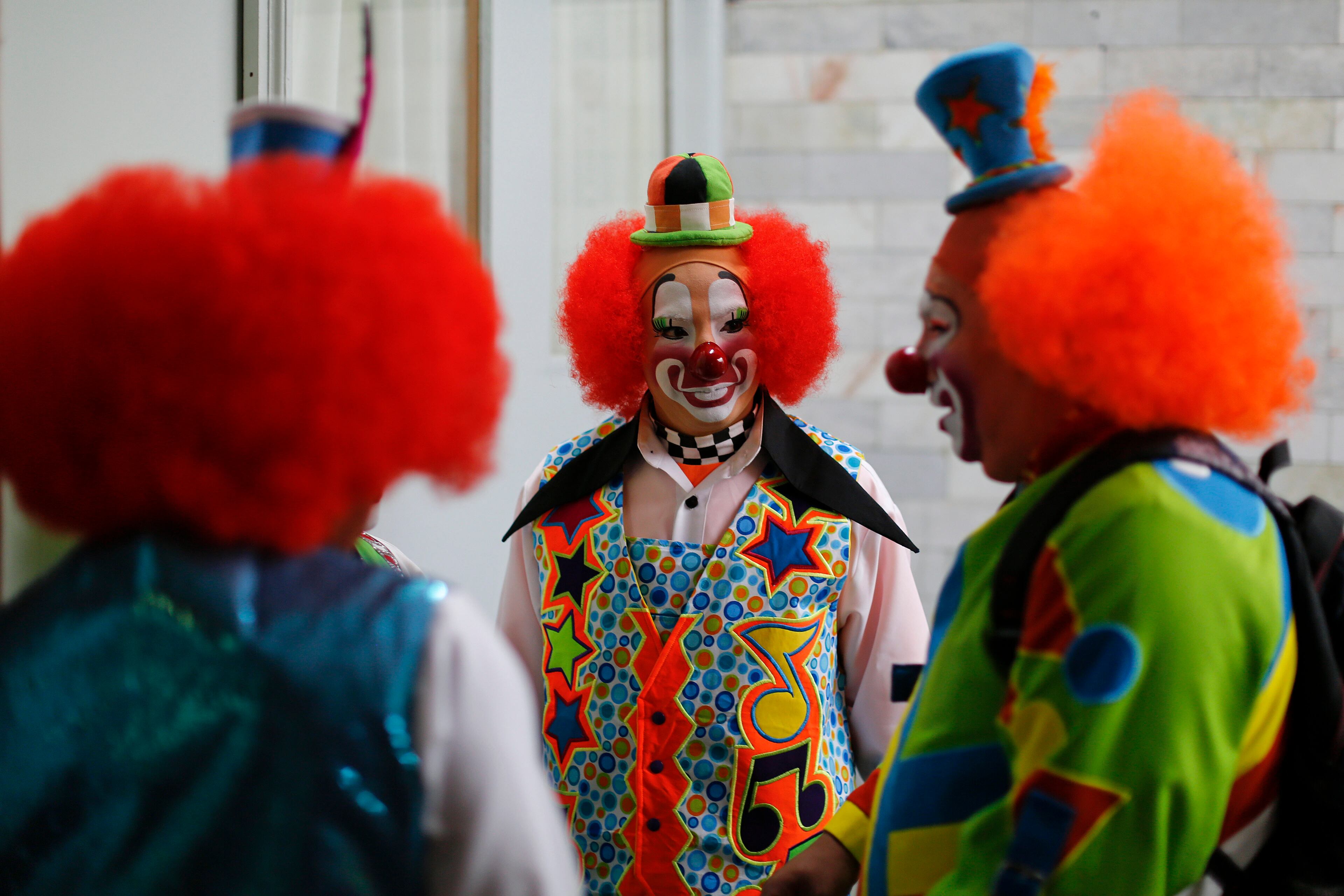 In this Monday, Oct. 21, 2013 photo, clowns chat after registering to attend the 17th International Clown Convention in Mexico City.