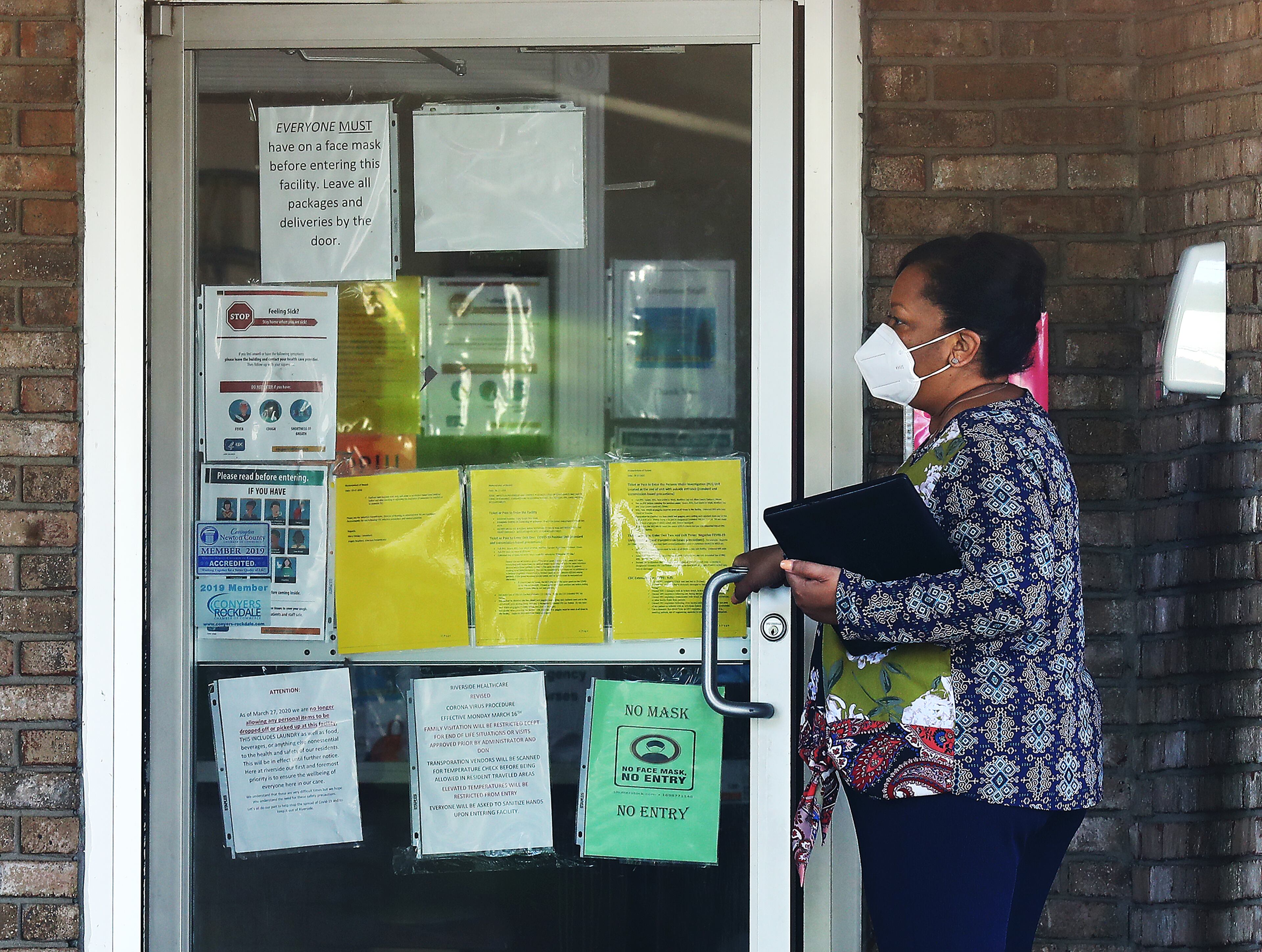 A woman enters the main entrance of Riverside Health Care nursing home. Reports now show that an outbreak in the nursing home that began in early July has ballooned as of Tuesday to 102 residents testing positive and 32 residents dying. (Curtis Compton / Curtis.Compton@ajc.com)
