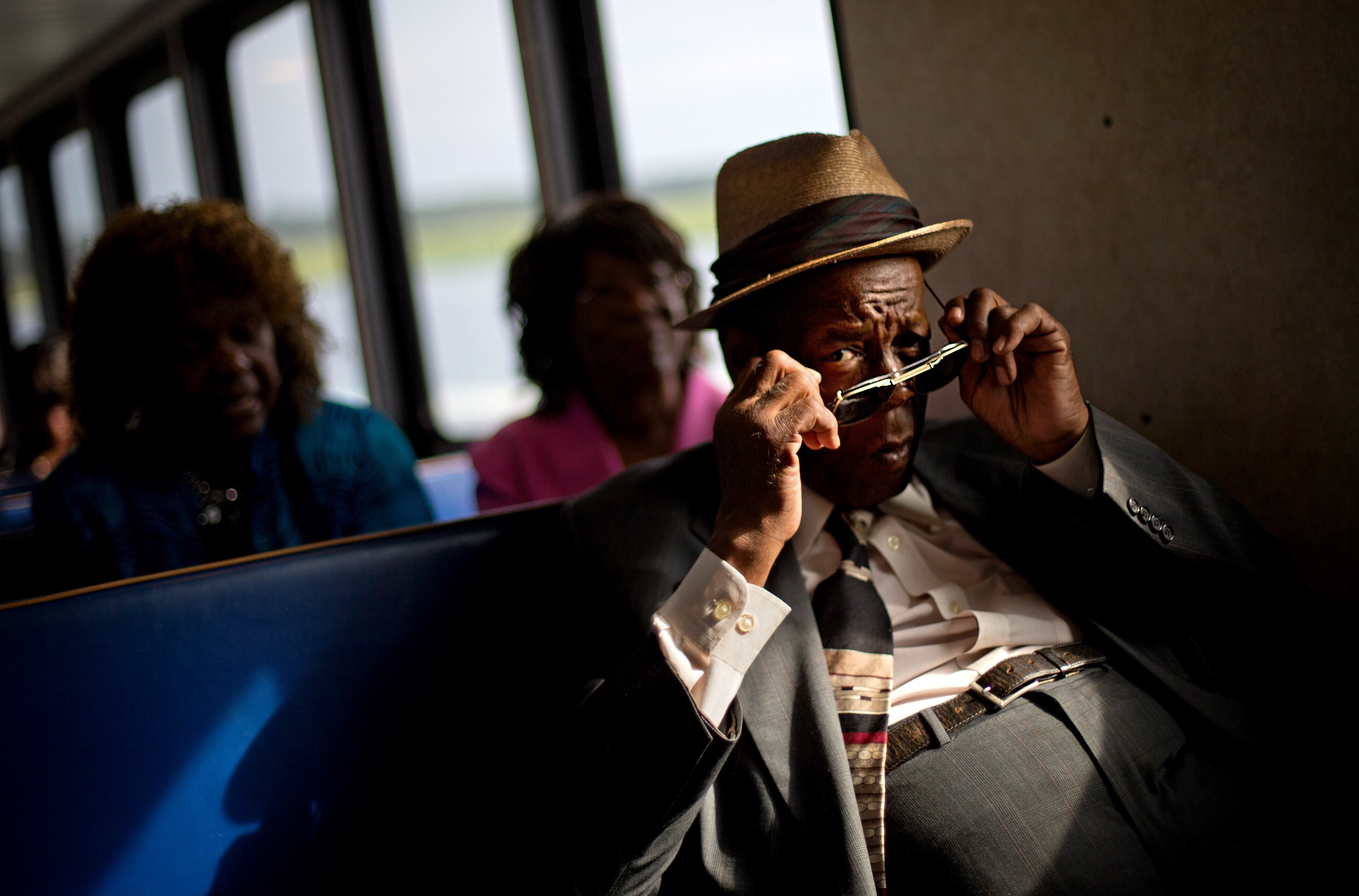 Eddie Wilson, 65, puts on his glasses while riding the ferry from the mainland to attend a church service for the 129th anniversary of St. Luke Baptist Church on Sapelo Island, Ga. on Sunday, June 9, 2013.