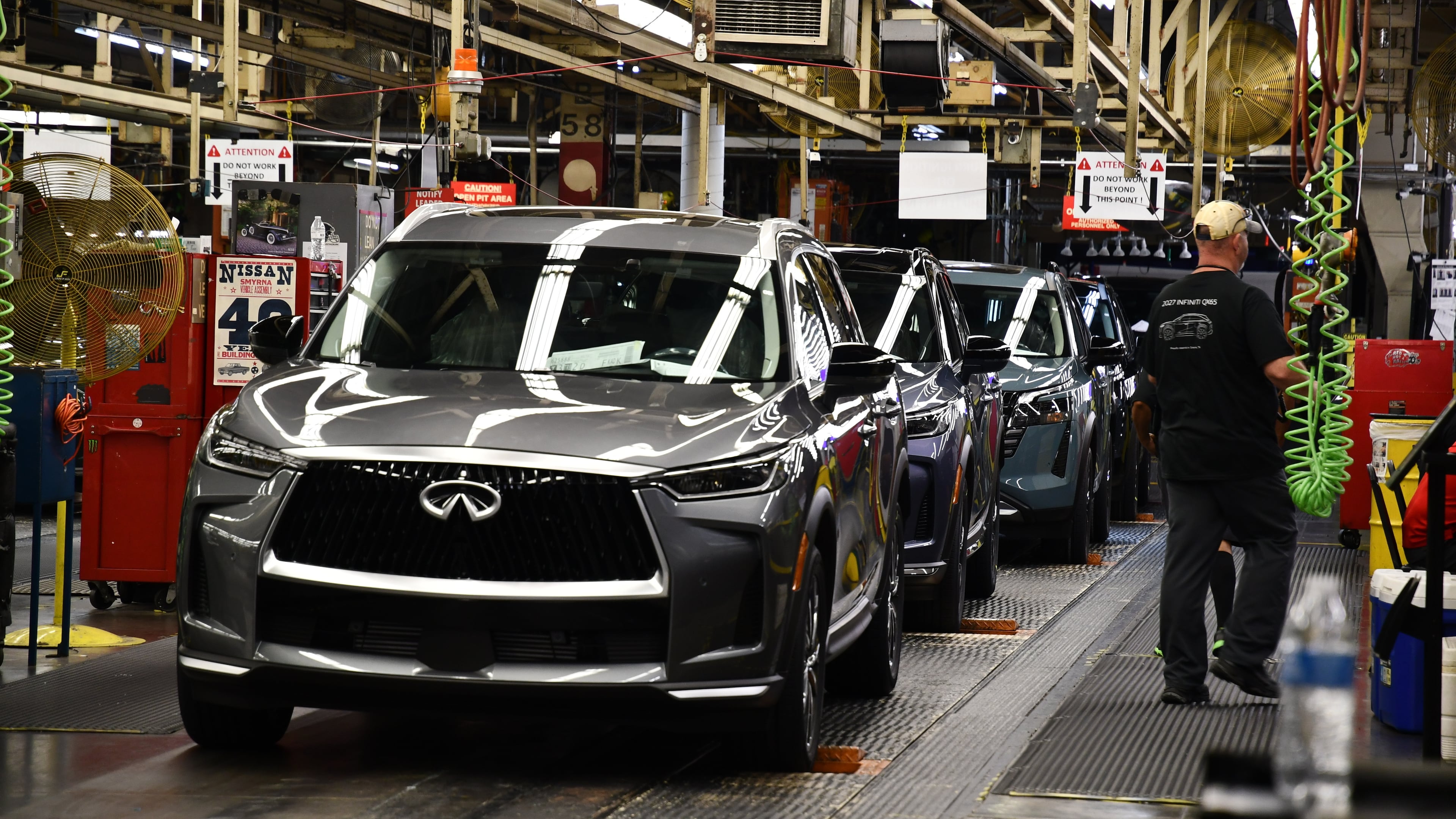 A worker walks past a line of Infiniti SUVs on a production line at the Nissan Smyrna Vehicle Assembly Plant, Thursday, April 16, 2026, in Smyrna, Tenn. (AP Photo/Kristin M. Hall)