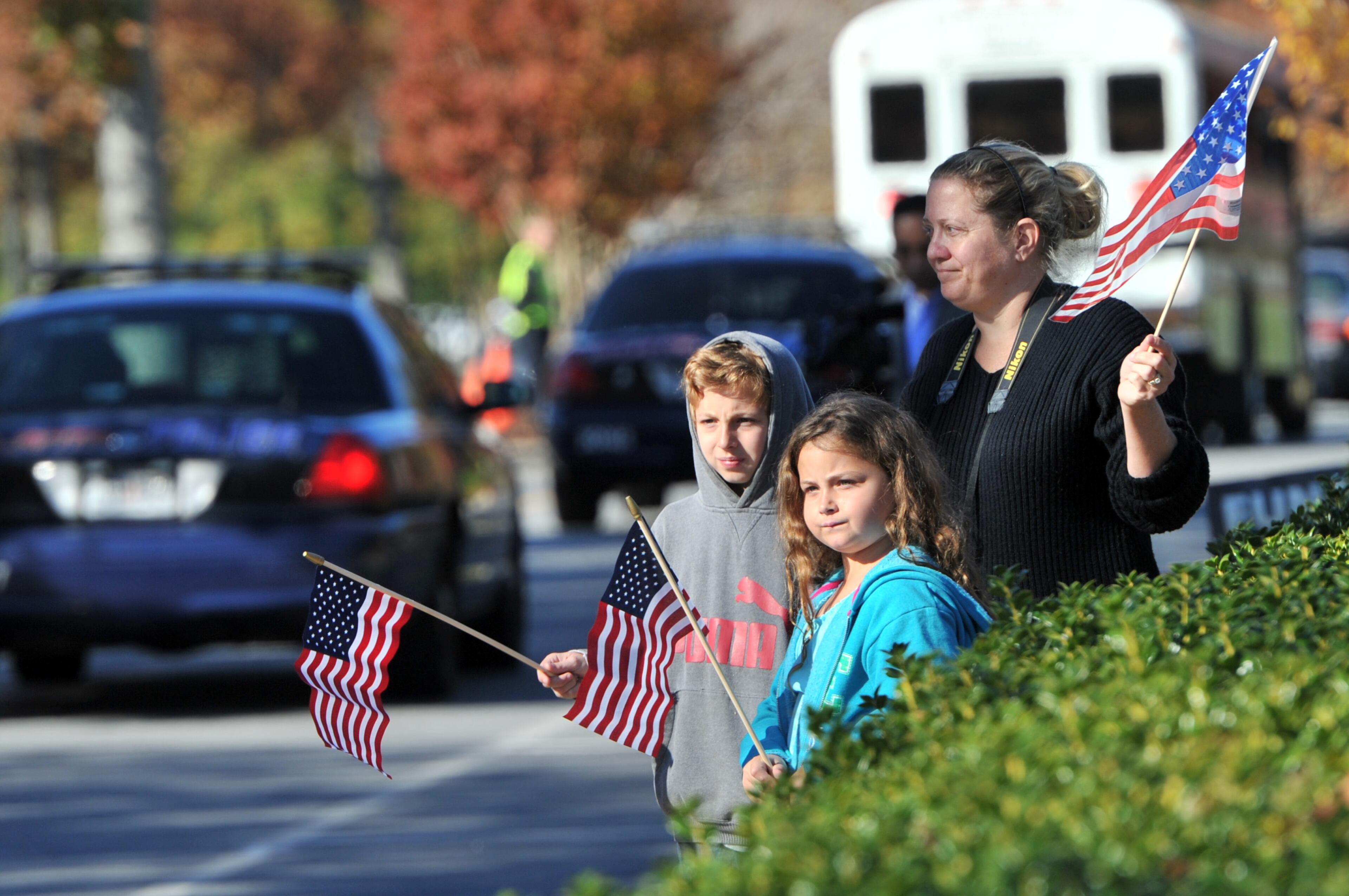 Tissy Jones, of Norcross, brought her two children Matthew (left), 10, and Madeline, 8, to show their respects as the motorcade pulls into the church before APD Officer Shawn Smiley's funeral at First Baptist Church of Atlanta on Saturday, November 10, 2012. APD Officer Shawn Smiley was in the passenger seat last weekend when an APD helicopter searching for a missing 9-year-old boy crashed in Atlanta. HYOSUB SHIN / HSHIN@AJC.COM