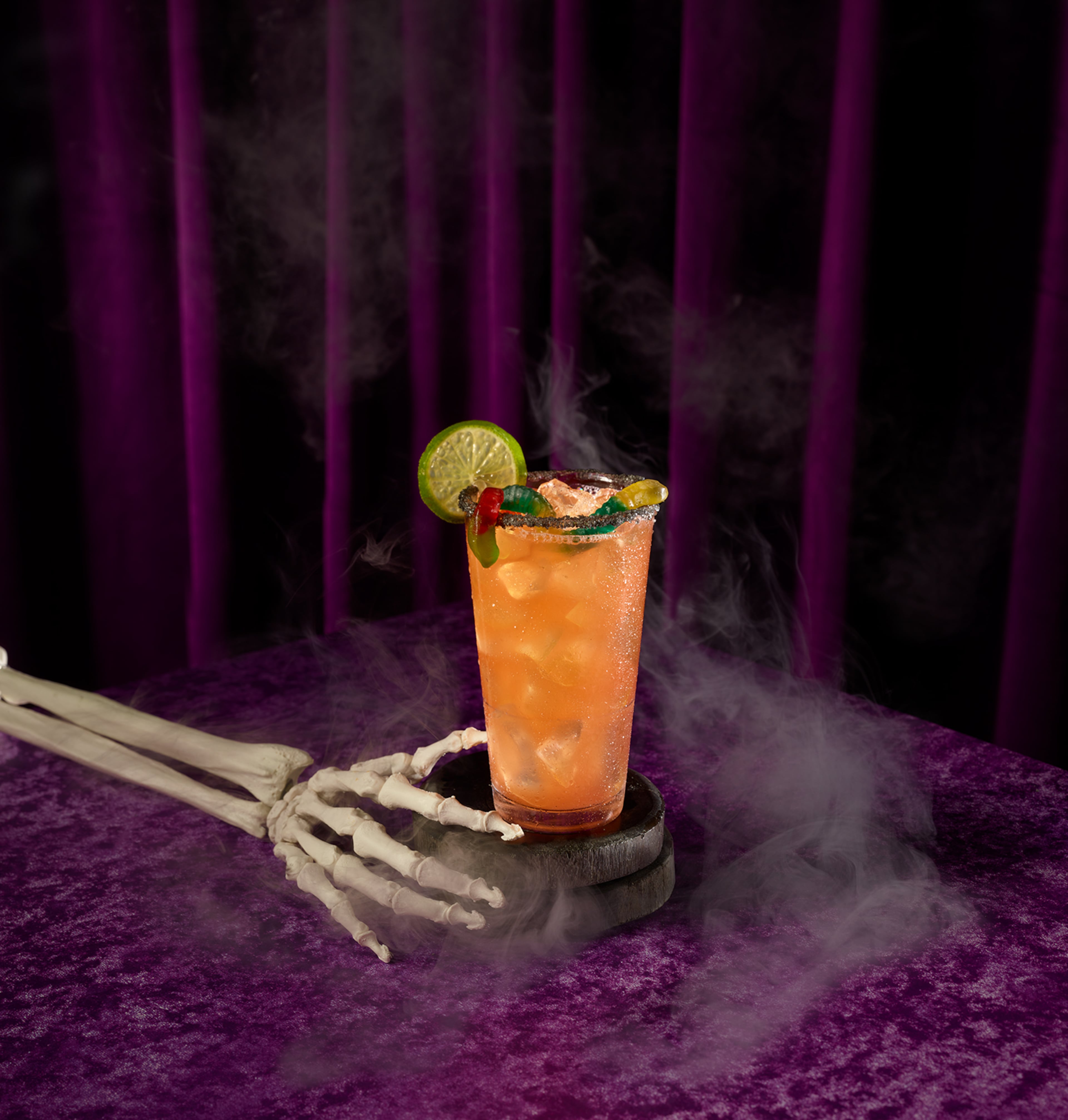 Blood orange and mango mingle with tequila in the Haunted Margarita at Top Golf, where they top it with gummy worms and a lava salt rim. (Courtesy of Top Golf)