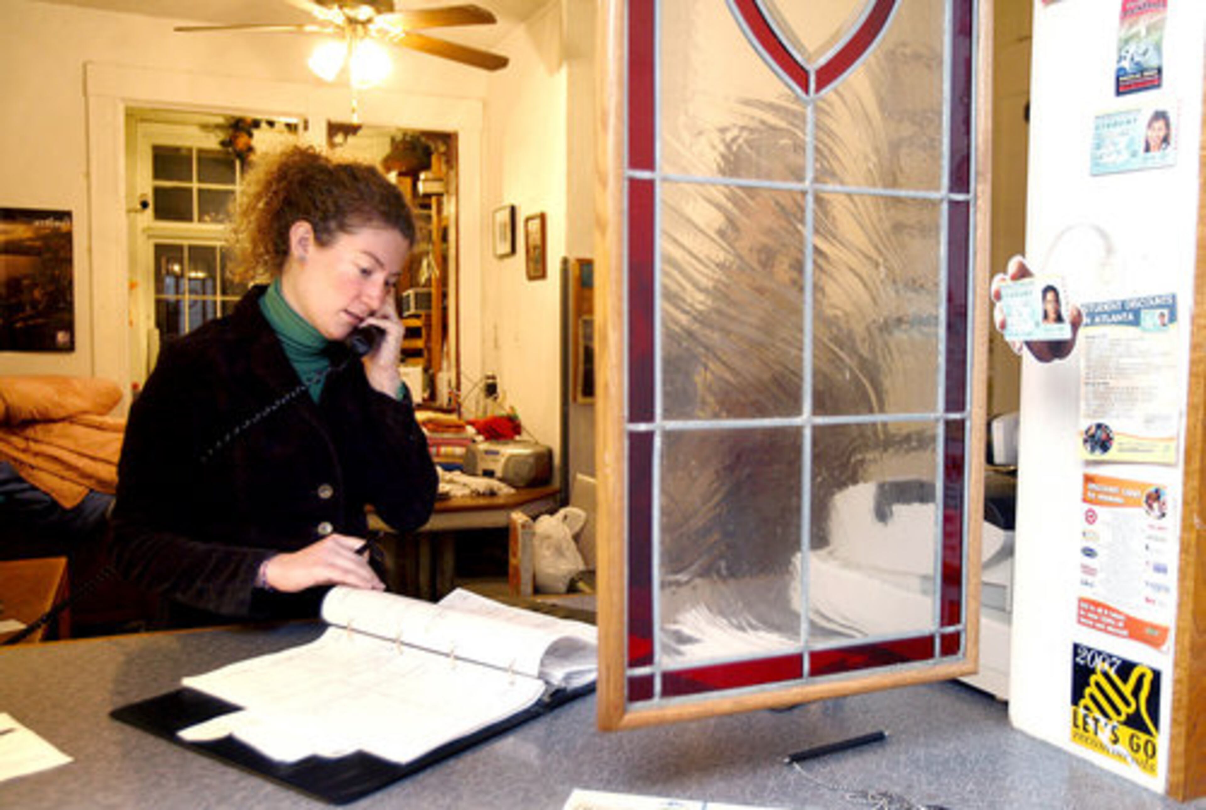 In the front office, Heather Harper, Atlanta International Hostel's assistant manager, takes a reservation for one of the hostel's 77 beds.