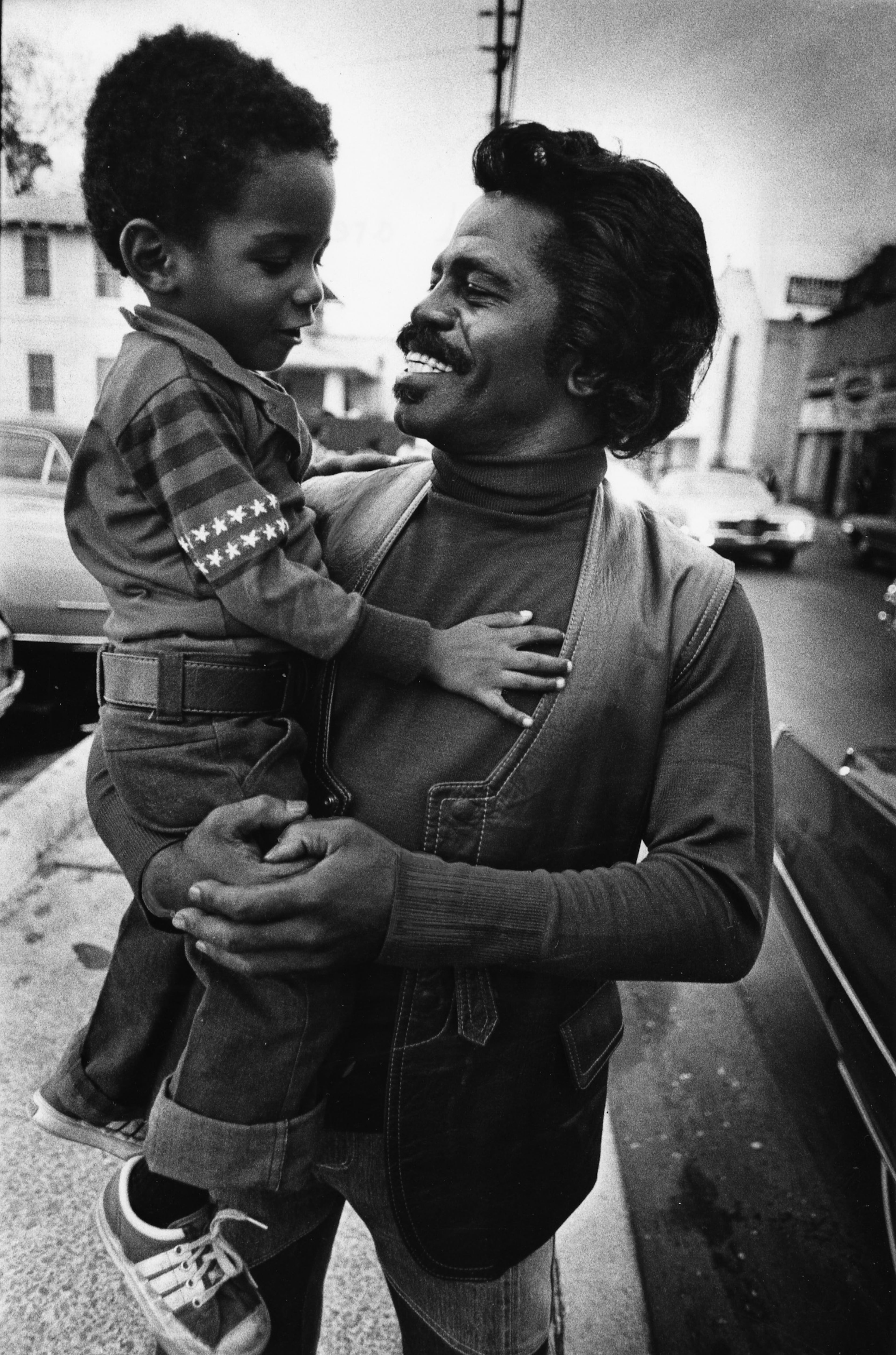 Augusta, GA -- James Brown holds an unidentified child and has the following dialog: Q: How old are you? A: 4 1/2 Q: Do you know who I am? A: James Brown Q: Do you know who is President? A: No Photo taken in 1977. (George Clark/AJC staff)