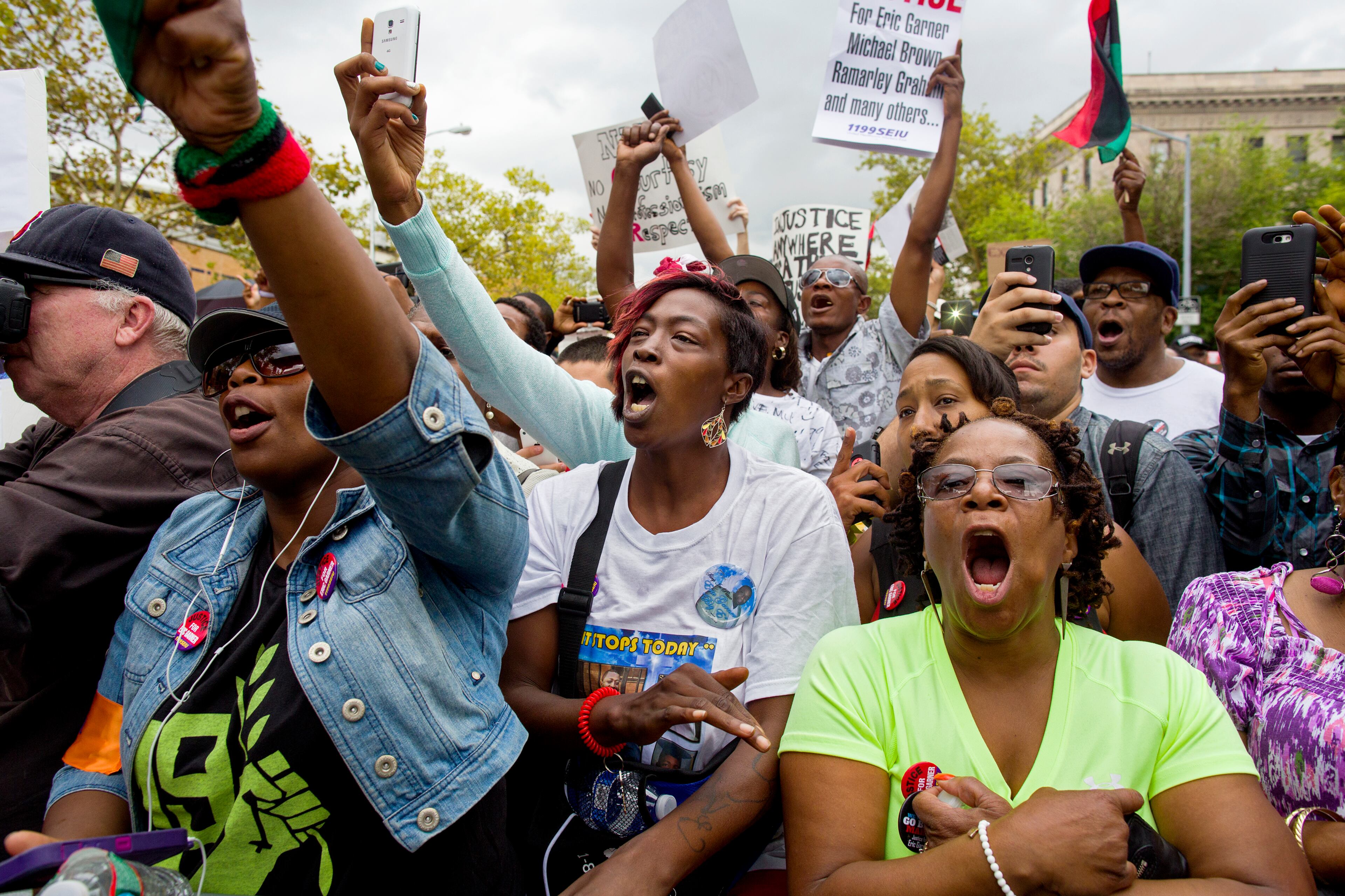 Attendees yell out at a march and rally to protest the death of Eric Garner, Saturday, Aug. 23, 2014, in the Staten Island borough of New York. The city medical examiner ruled that Eric Garner, 43, died as a result of a police chokehold during an attempted arrest. The march was led by the Rev. Al Sharpton's National Action Network. (AP Photo/Craig Ruttle)