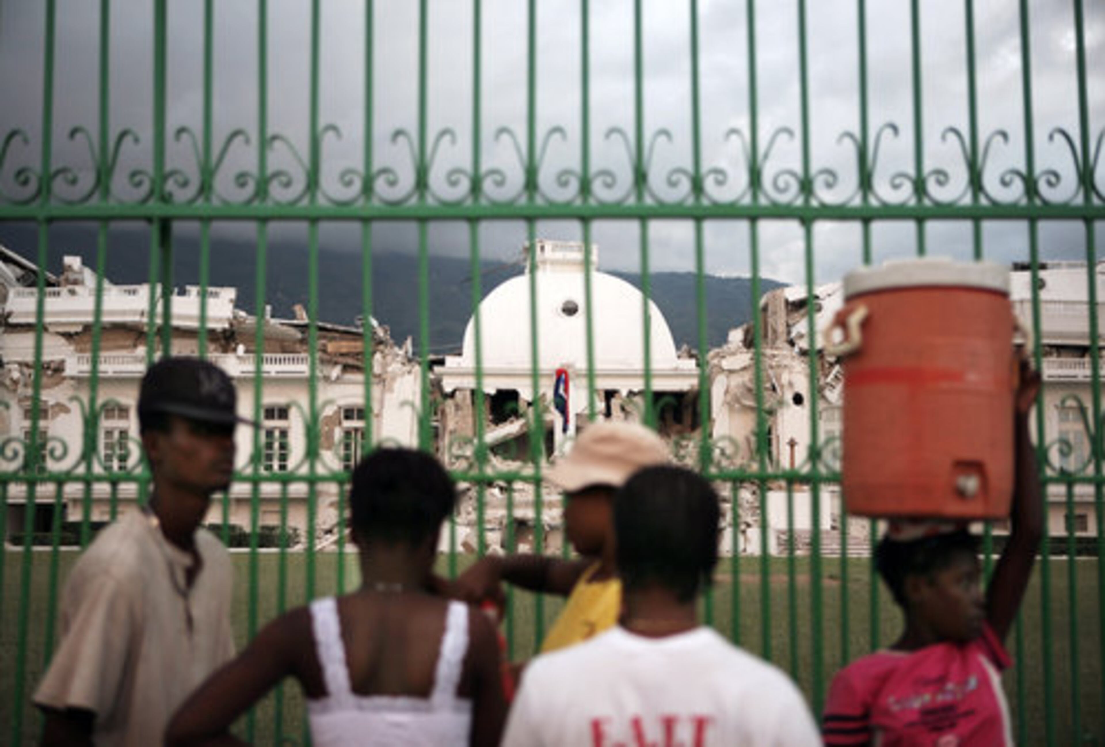 Local residents look at the damaged National Palace in Port-au-Prince, Haiti, on Wednesday, Jan. 13, 2010. Huge swaths of Port-au-Prince lay in ruins, and thousands of people were feared dead in the rubble of government buildings, foreign aid headquarters and shantytowns that collapsed a day earlier in a powerful earthquake.