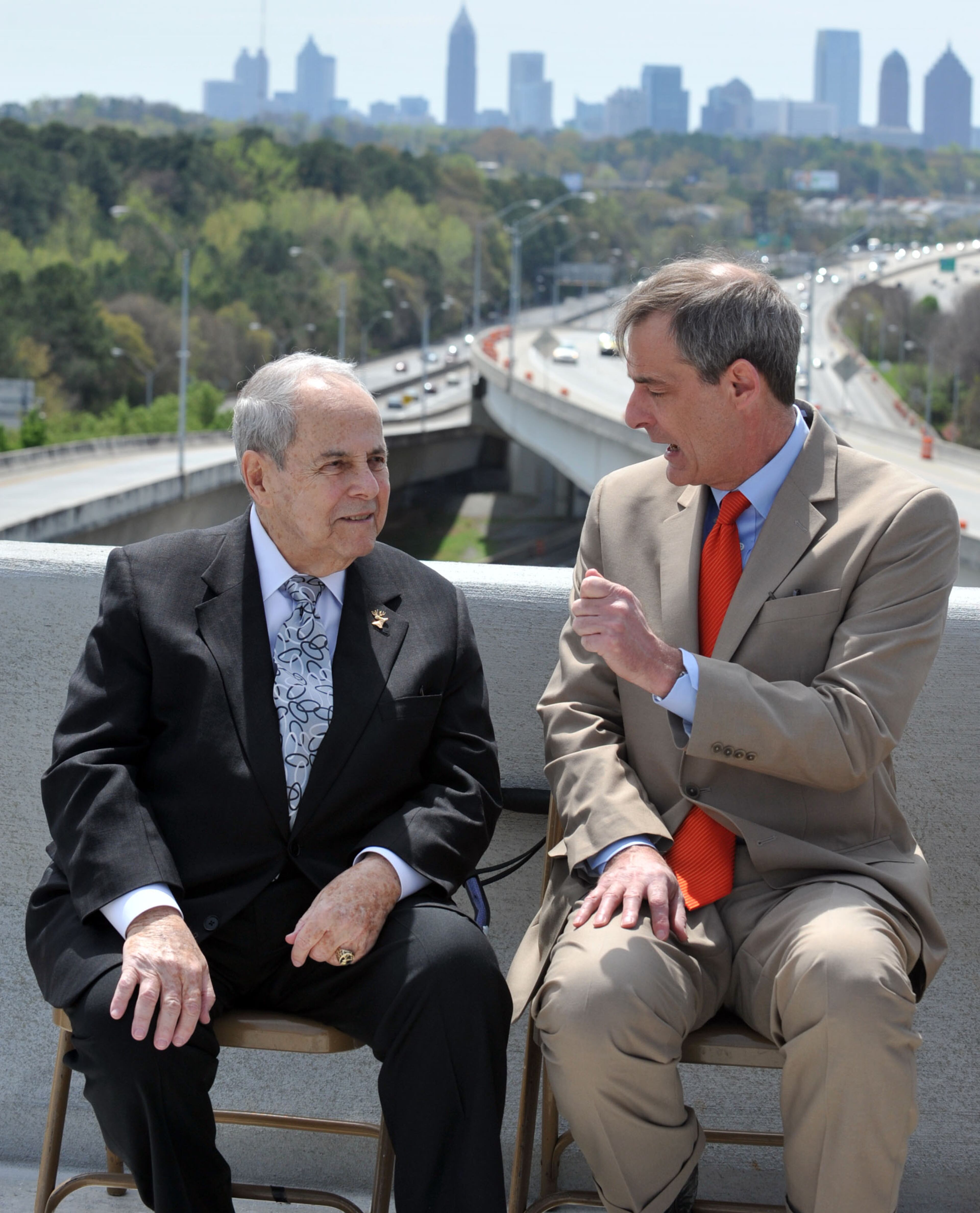 Former Atlanta Mayor Sam Massell (left) talks with Atlanta City Councilman Howard Shook. Governor Nathan Deal and other state and local leaders conducted a brief ribbon-cutting celebration of the opening of the new flyover ramps Wednesday, April 2, 2014. The ramps provide I-85 southbound traffic with direct access to GA 400 northbound and also give GA 400 southbound motorists a direct ramp to I-85 northbound.