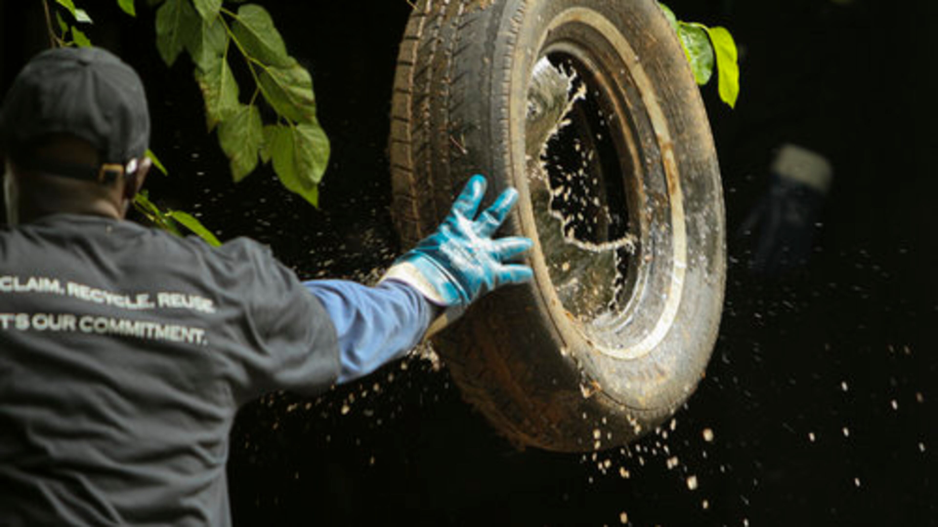 Laba Mbengue throws a tire full of water into his truck back in 2011. Mbengue, a long-time driver at Liberty Tire Recycling, helped organize the workers, who voted in October to join the Teamsters. On Friday, the workers unanimously approved the first contract negotiated with the company.