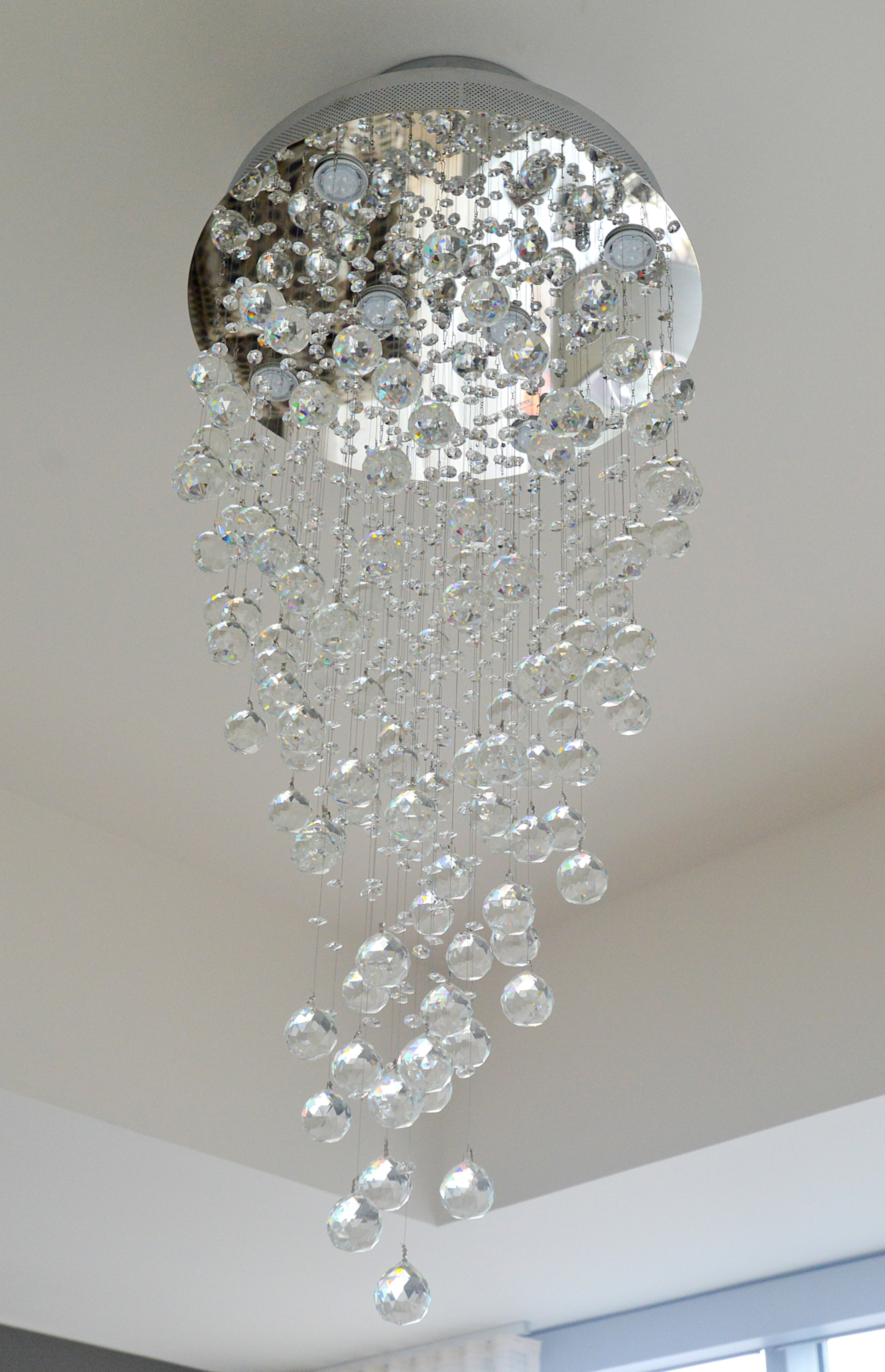 A contemporary chandelier from Masterpiece Lighting adds to the modern feel of the master bedroom