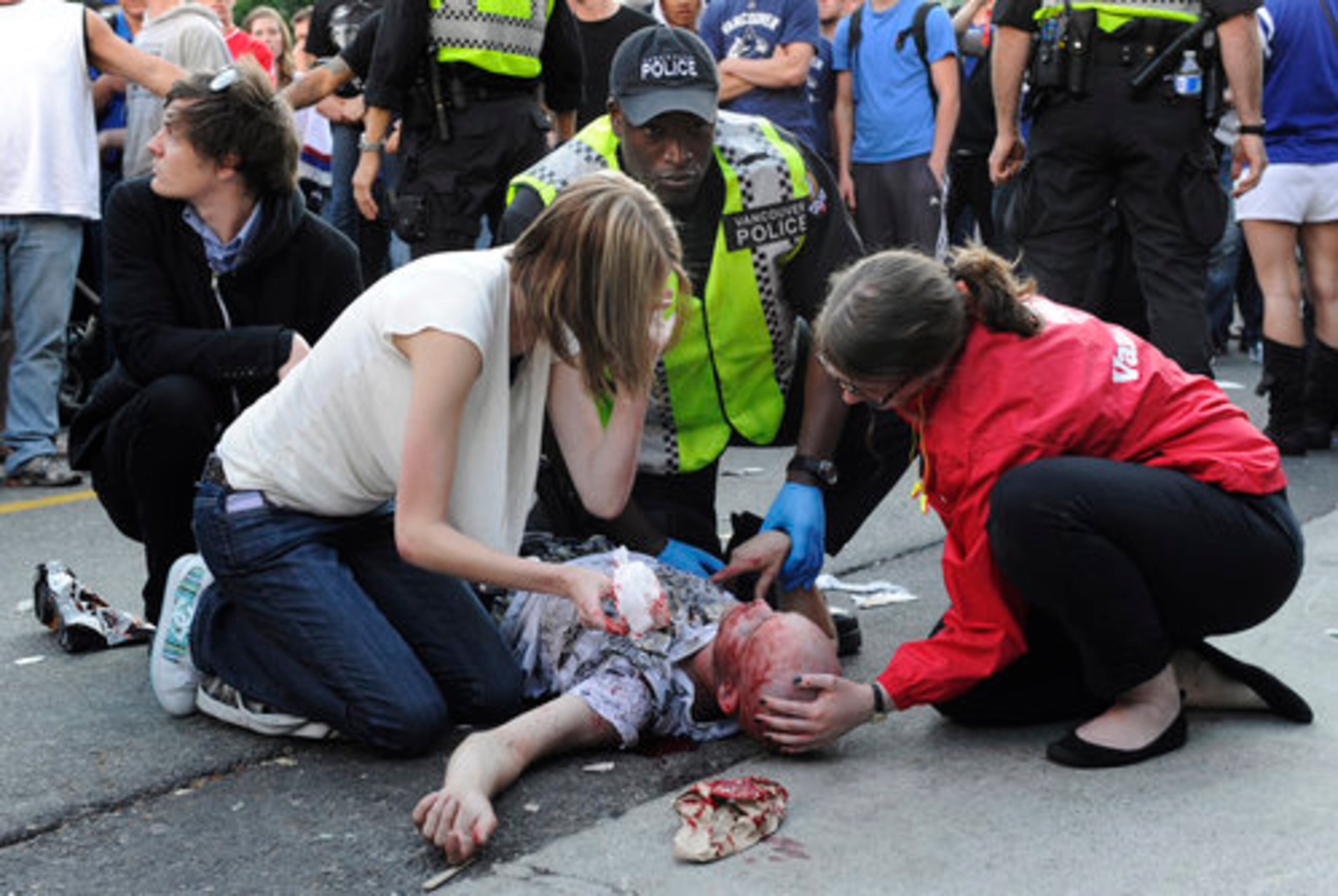 Fans and officals give first aid to an unconscious man injured in a fight. While there had been no fatalities, ambulances appeared to be having trouble getting to those who needed help.