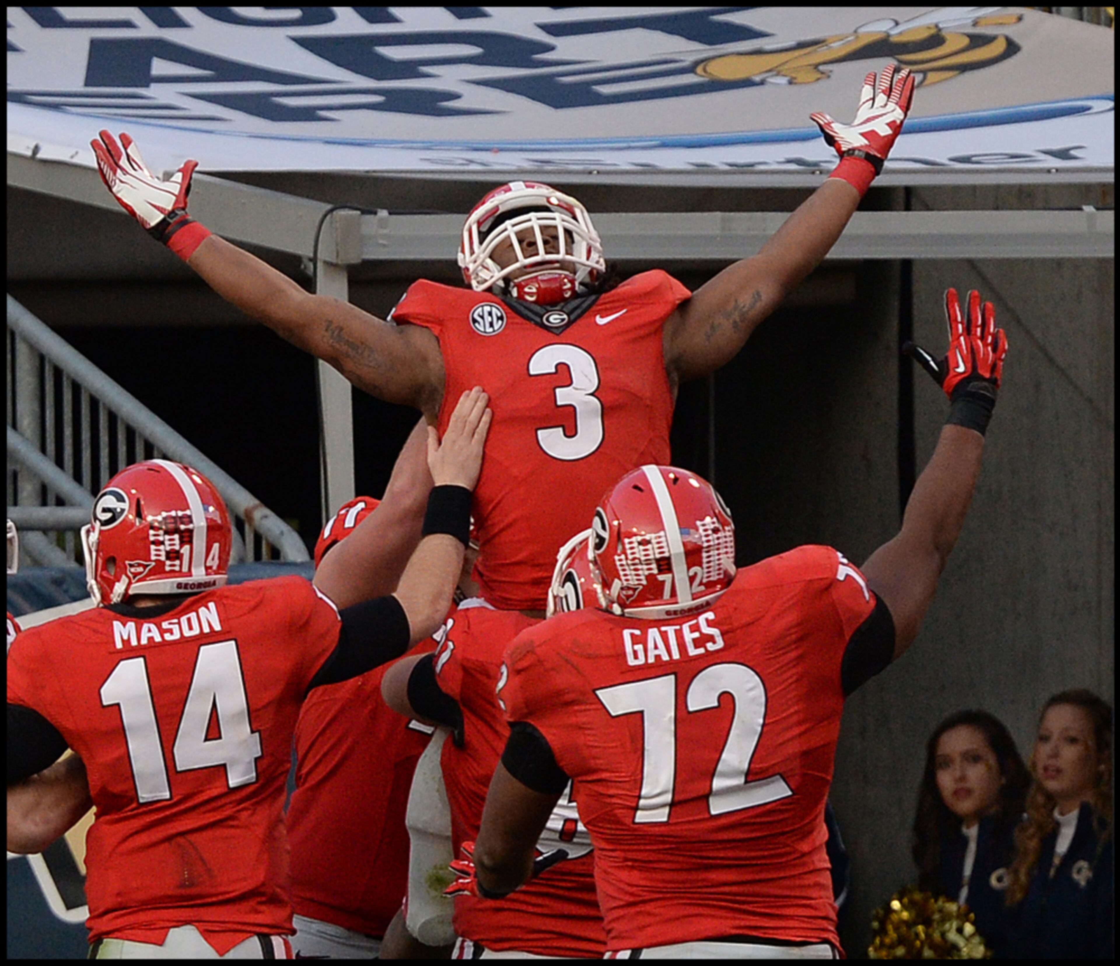 November 30, 2013 - Atlanta: I took this photo from over 120 yards while standing behind the opposite end zone using my Nikon D4 and Nikon 500 f4 lens. Georgia's Todd Gurley celebrates after scoring a touchdown in the second half in Bobby Dodd Stadium on Saturday, November 30, 2013. Camera Nikon D4, Nikon 500 f4, ISO 1600, Aperture f4, Shutter Speed 1/1250. JOHNNY CRAWFORD / JCRAWFORD@AJC.COM