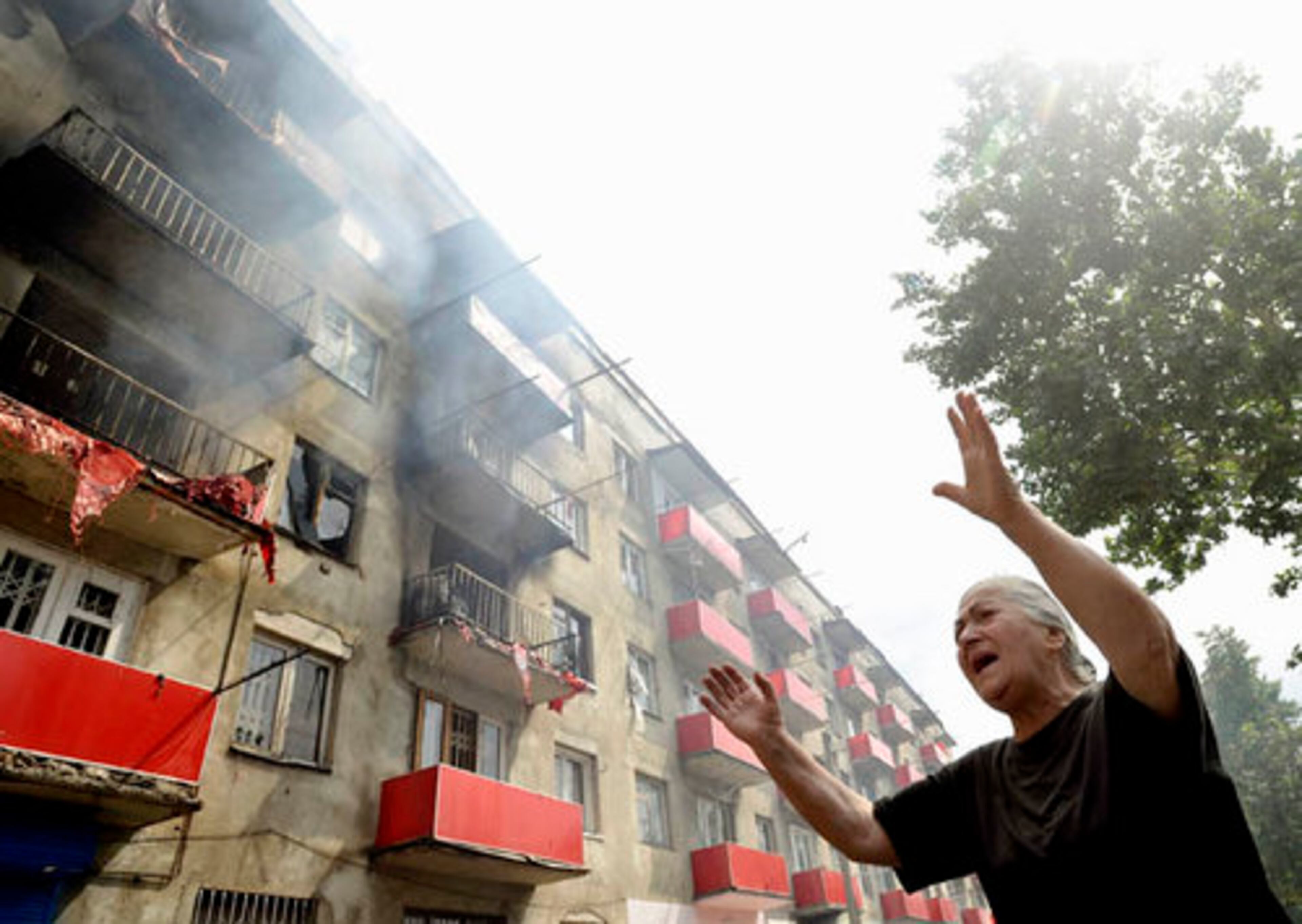 A Georgian woman reacts beside her burning apartment building in the city of Gori.