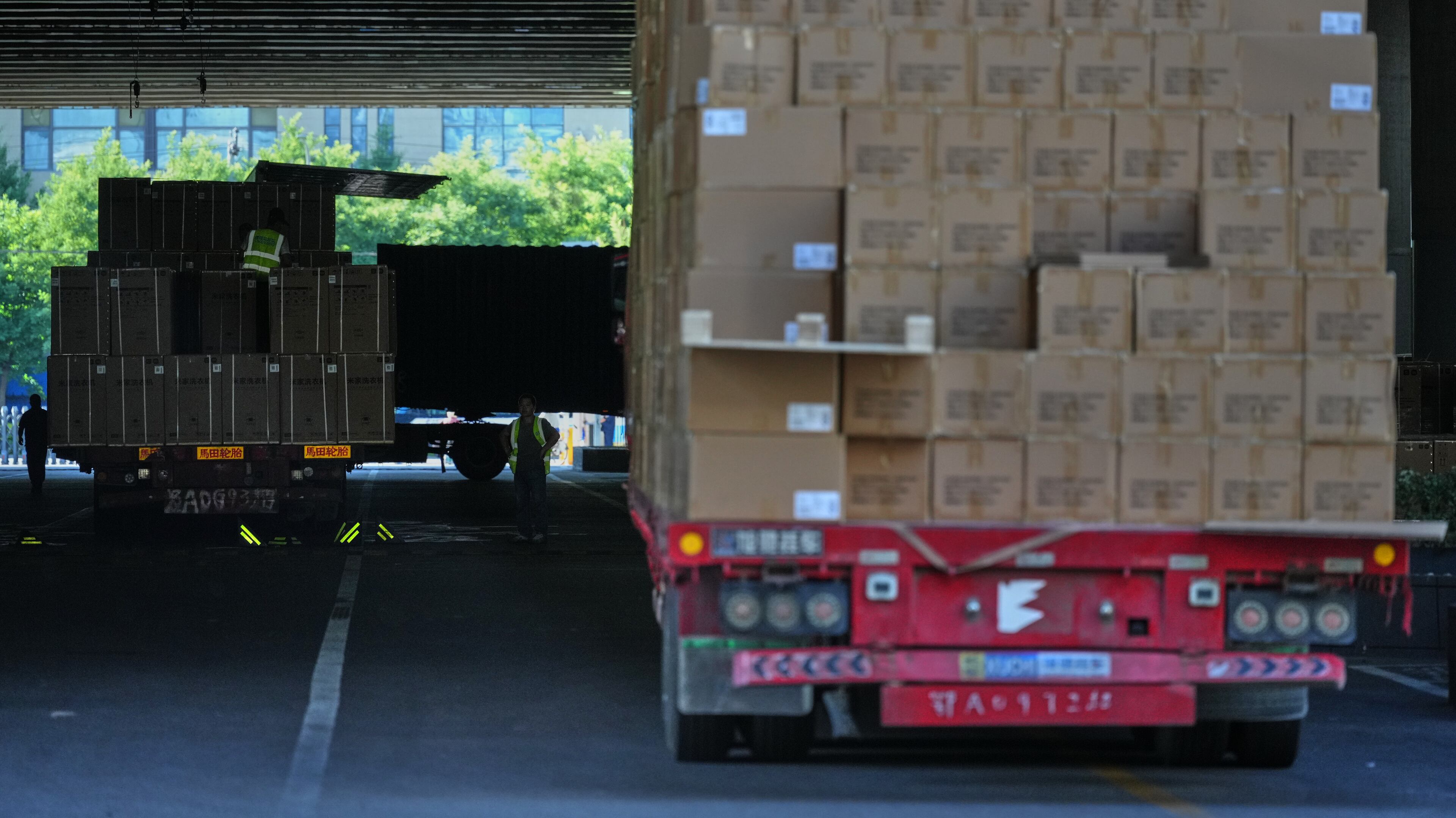 Workers transfer goods from a truck at the Xiaomi logistic center, in Beijing, China on Friday, May 29, 2026. (AP Photo/Andy Wong)