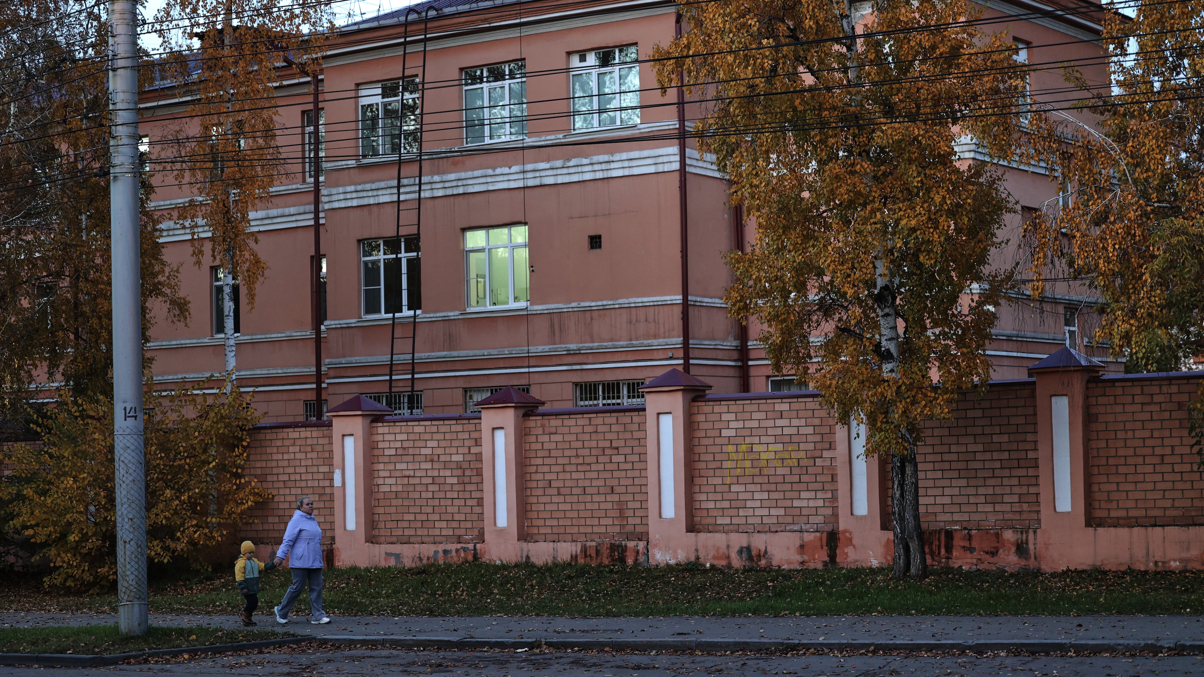 A woman with her child walks past the building of the Irkutsk Anti-Plague Research Institute of Siberia and the Far East in Irkutsk, Russia, on Wednesday, Oct. 7, 2026. (AP Photo)