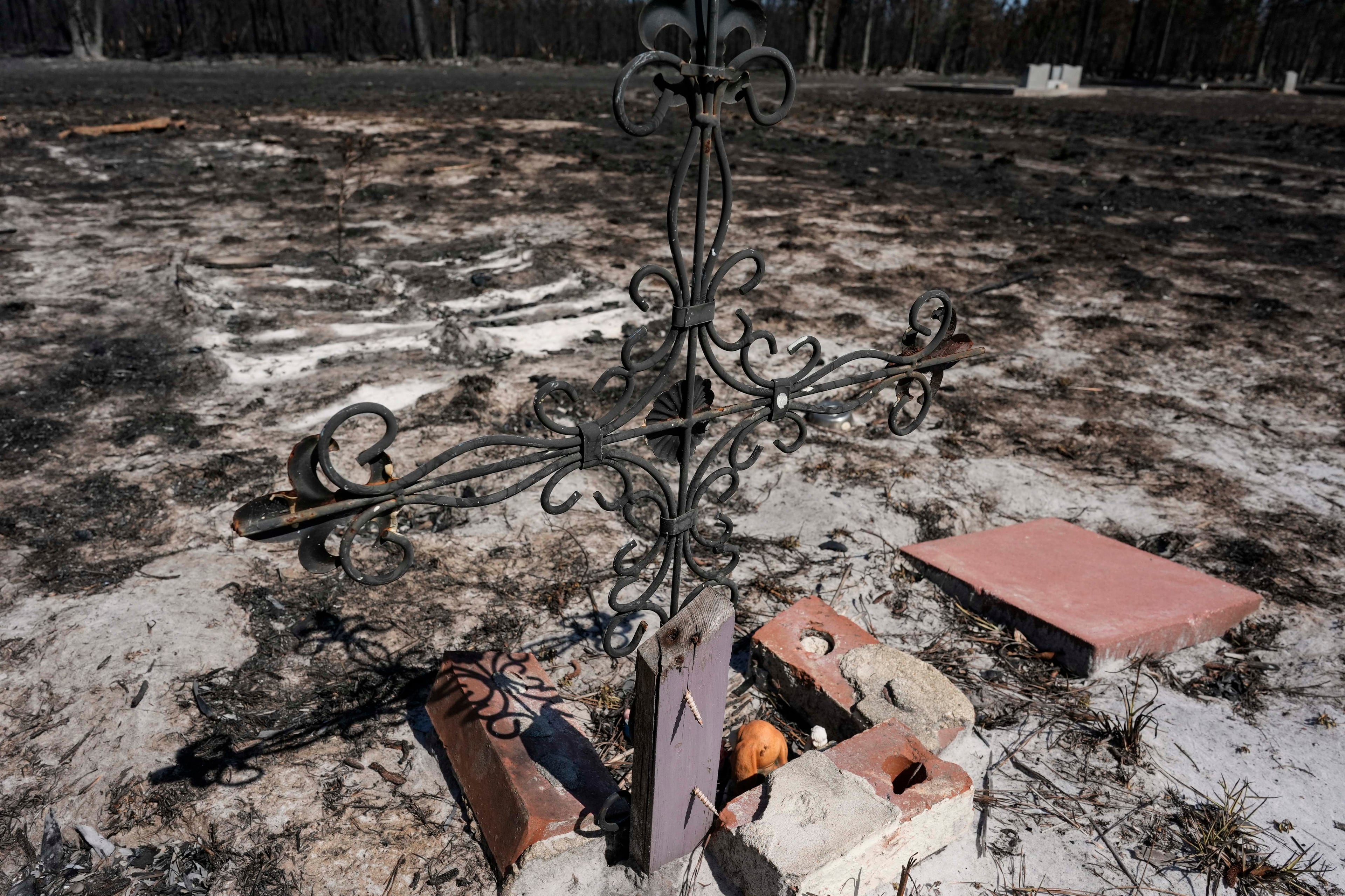 A grave marker in a cemetery is burned near destroyed homes as the Brantley Highway 82 fire continues to burn on Thursday, April 23, 2026, near Nahunta. (Mike Stewart/AP)