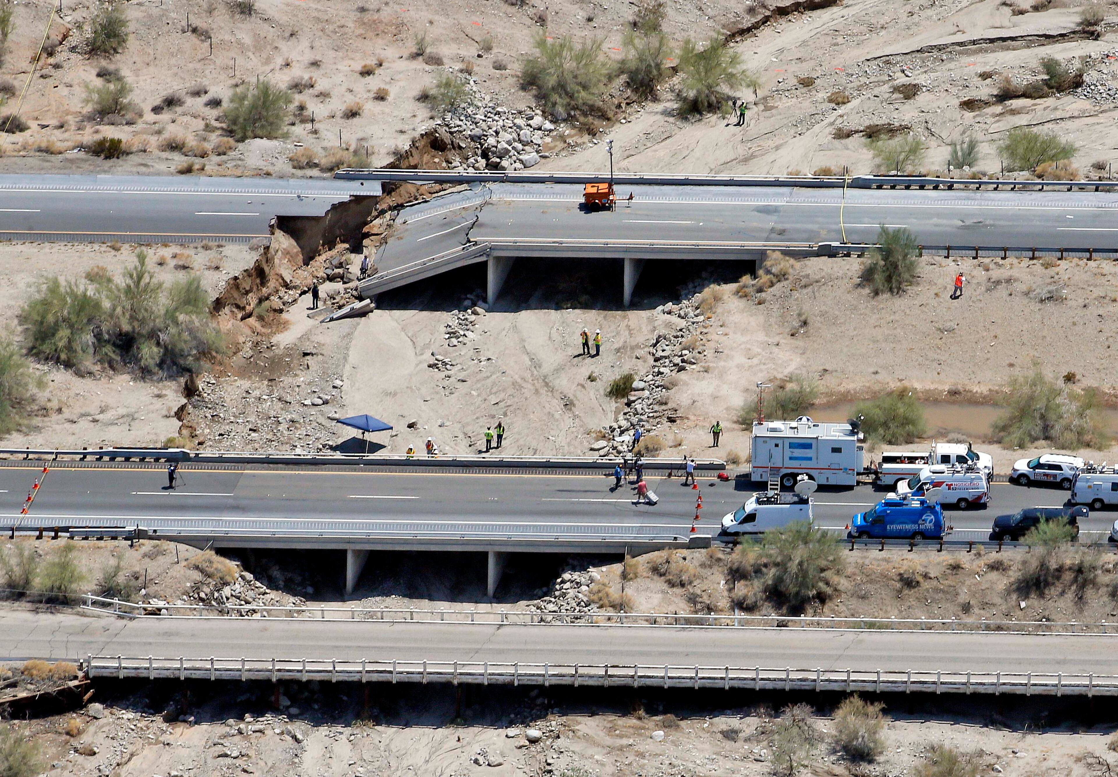 A collapsed elevated section of Interstate 10 is seen from the air, Monday, July 20, 2015, in Desert Center, Calif. All traffic along one of the major highways connecting California and Arizona was blocked indefinitely when the bridge over a desert wash collapsed during a major storm, and the roadway in the opposite direction sustained severe damage. (AP Photo/Matt York)