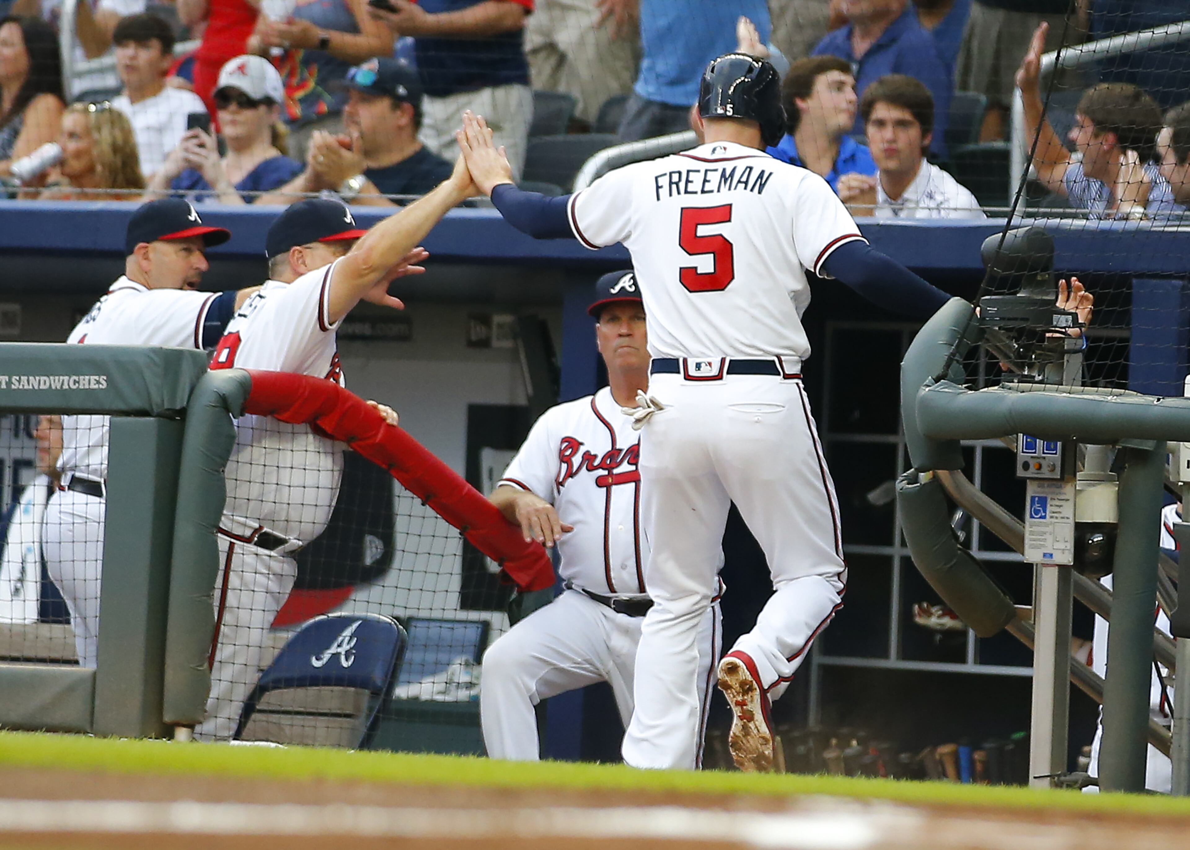 Freddie Freeman #5 of the Atlanta Braves celebrates scoring as he enters the dugout in the first inning of an MLB game against the Arizona Diamondbacks at SunTrust Park on July 13, 2018 in Atlanta, Georgia. (Photo by Todd Kirkland/Getty Images)