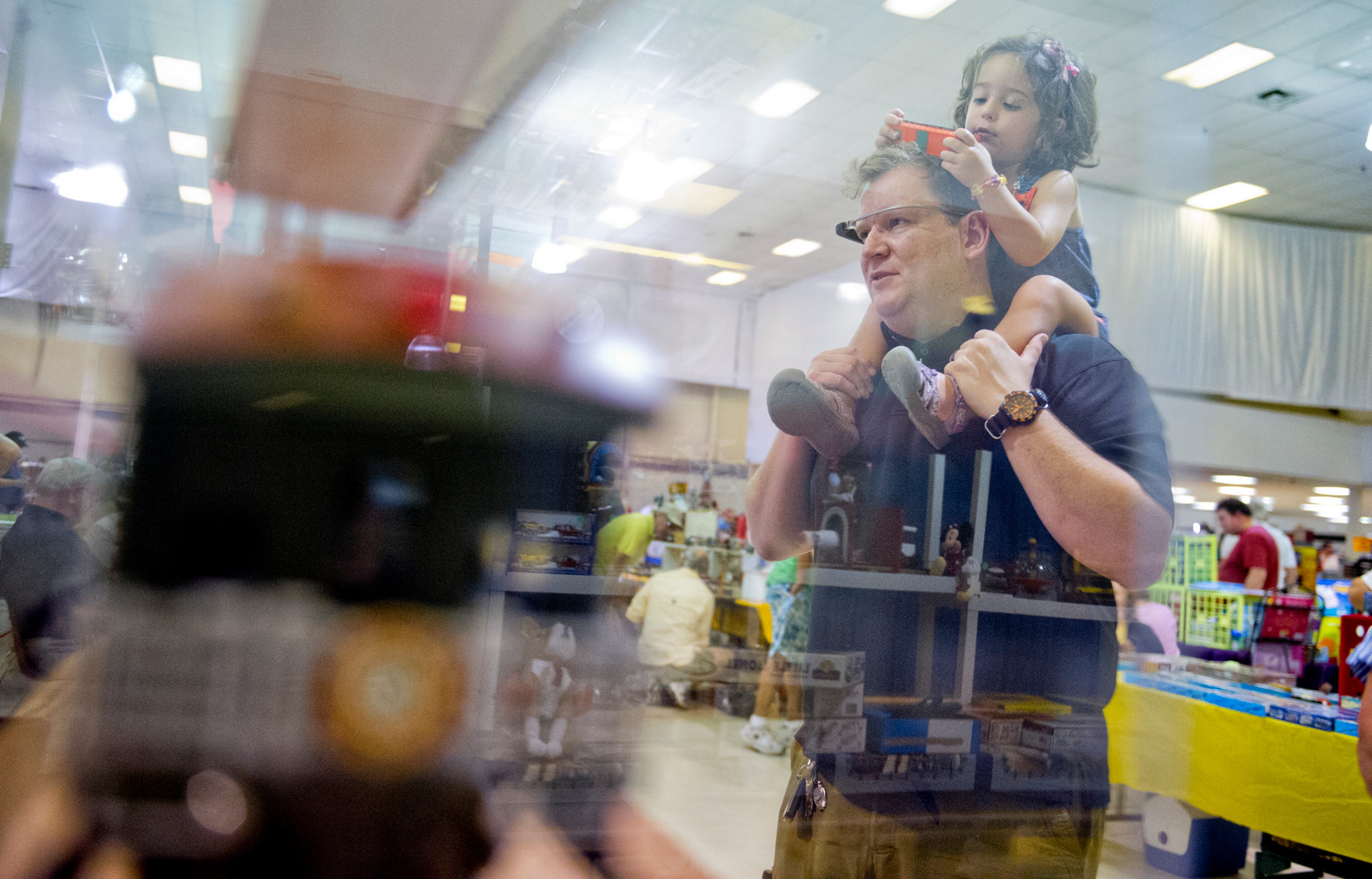 Zoya Starbird (right) holds a train car as she sits on her father Ray's shoulders as they look at different displays during the 47th Atlanta Model Train and Railroadiana Show and Sale at the North Atlanta Trade Center in Norcross on Saturday, August 9, 2014. The show featured over 300 tables representing dealers from all over the nation showing railroad model items in all gauges as well as railroad antiques. JONATHAN PHILLIPS / SPECIAL