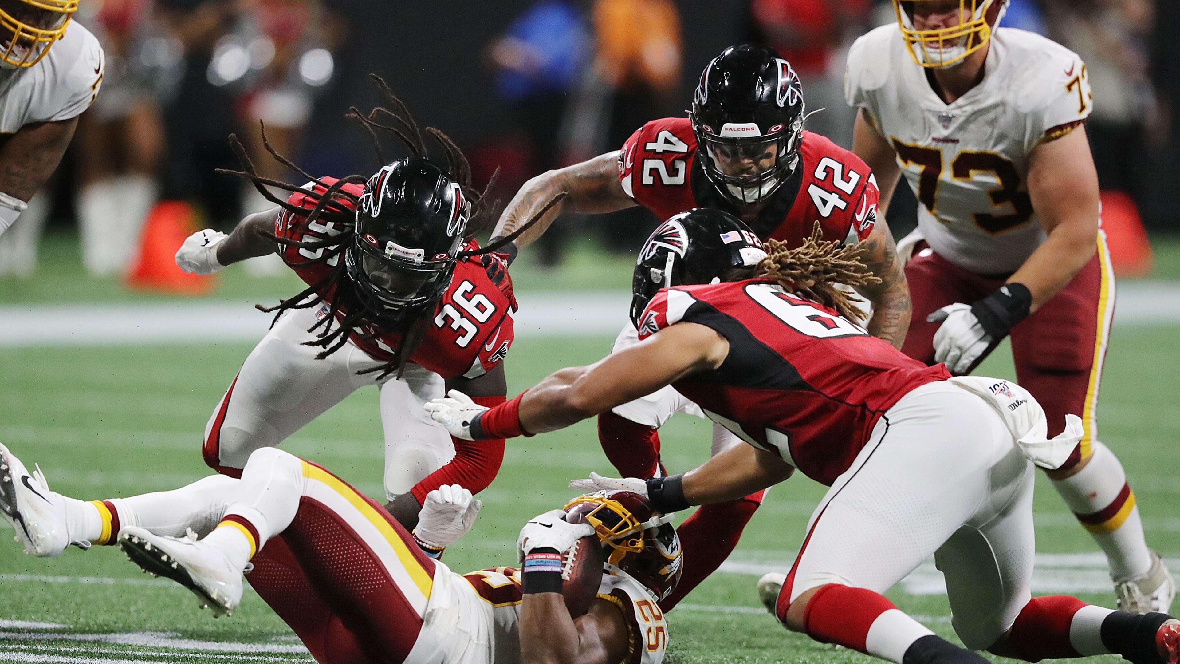 Falcons defenders (from left) Kemal Ishmael, Duke Riley, and Austin Larkin take down Washington Redskins running back Chris Thompson. Curtis Compton/ccompton@ajc.com