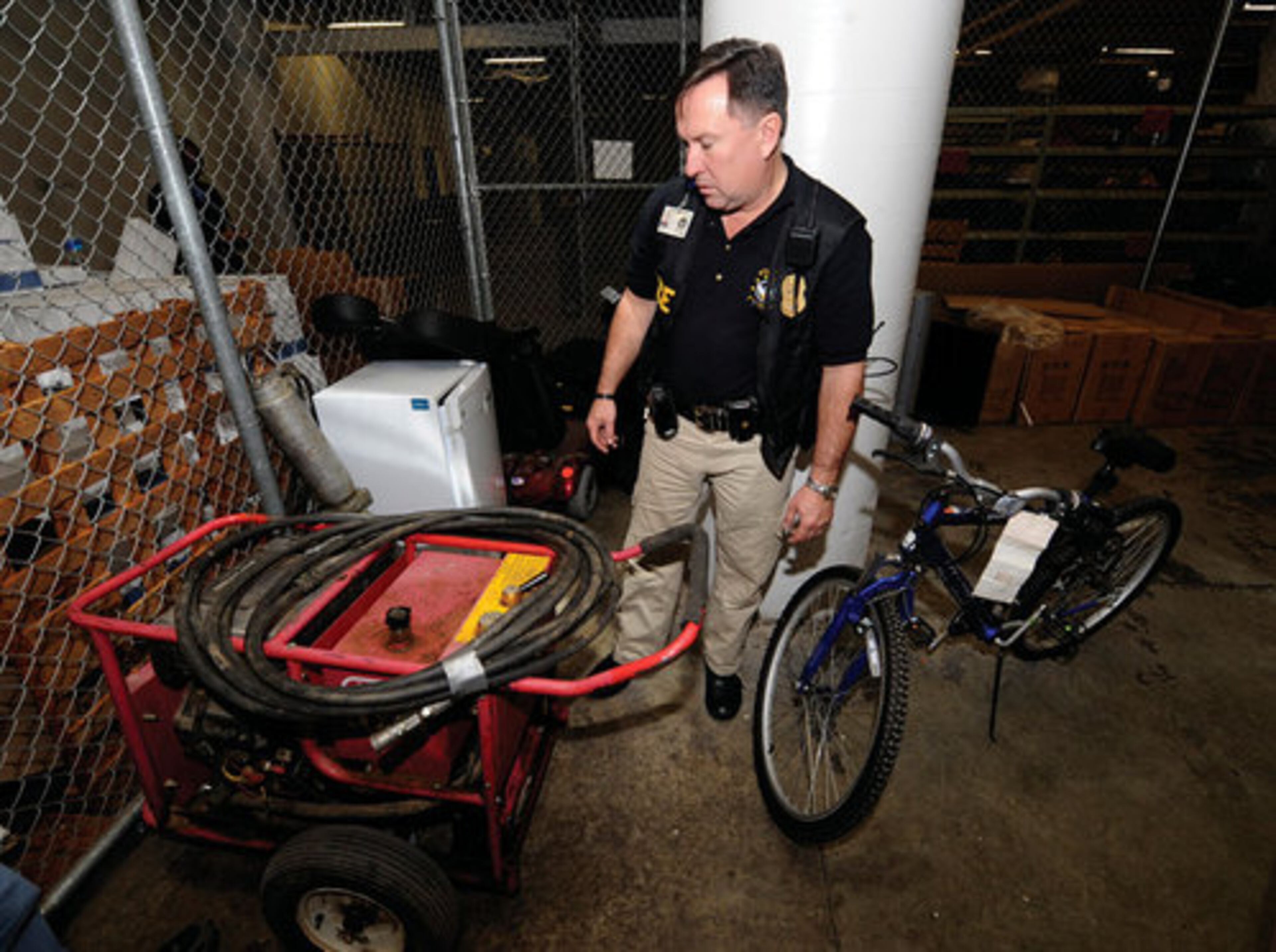 J.P. Spillane, Assistant Commander of Zone 5 of the Atlanta Police Department, looks for the serial numbers on a pressure washer.