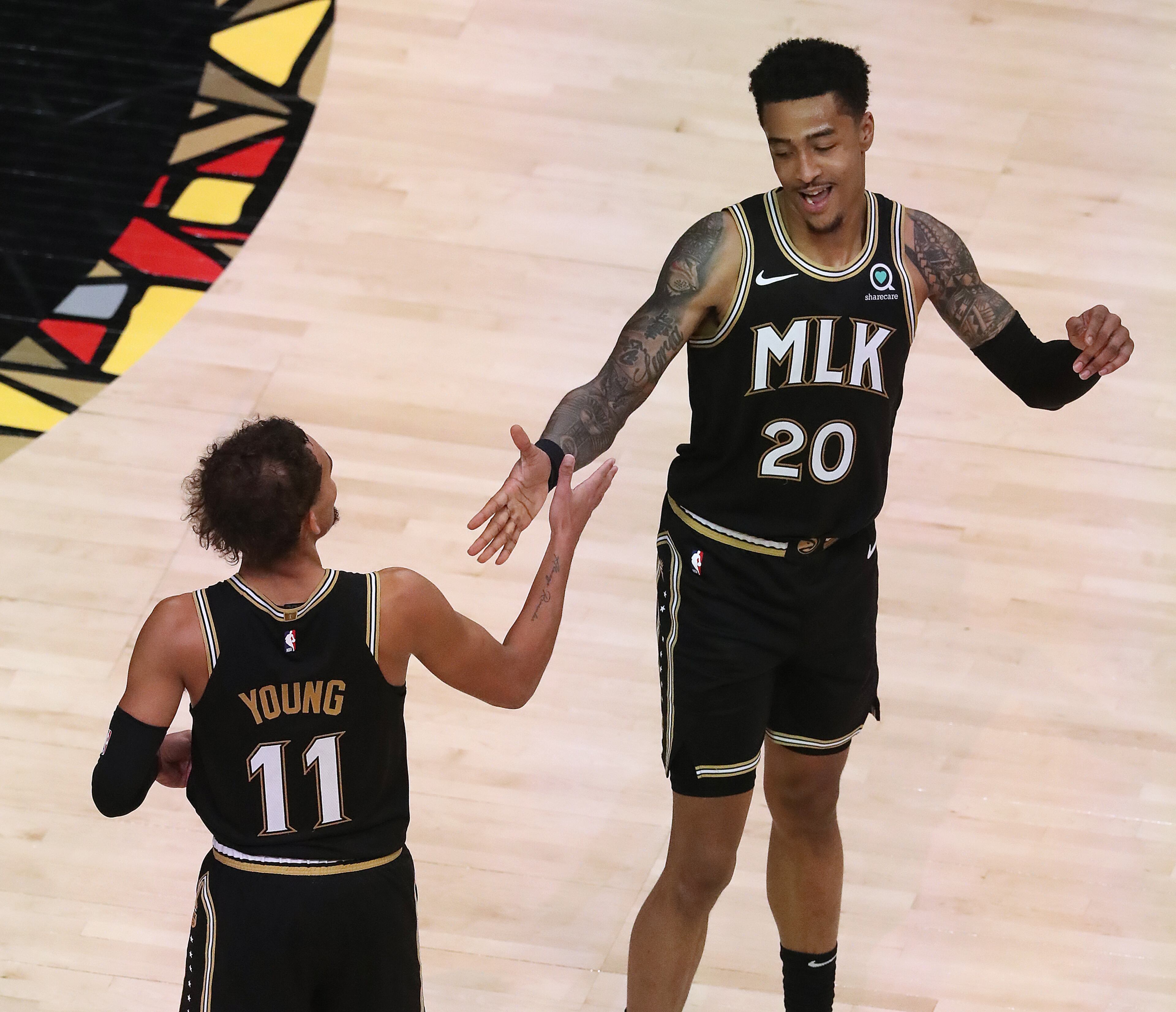 Hawks guard Trae Young (left) and forward John Collins celebrate a 108-99 victory over the Los Angeles Clippers in an NBA basketball game on Tuesday, Jan. 26, 2021, in Atlanta. Curtis Compton / Curtis.Compton@ajc.com”