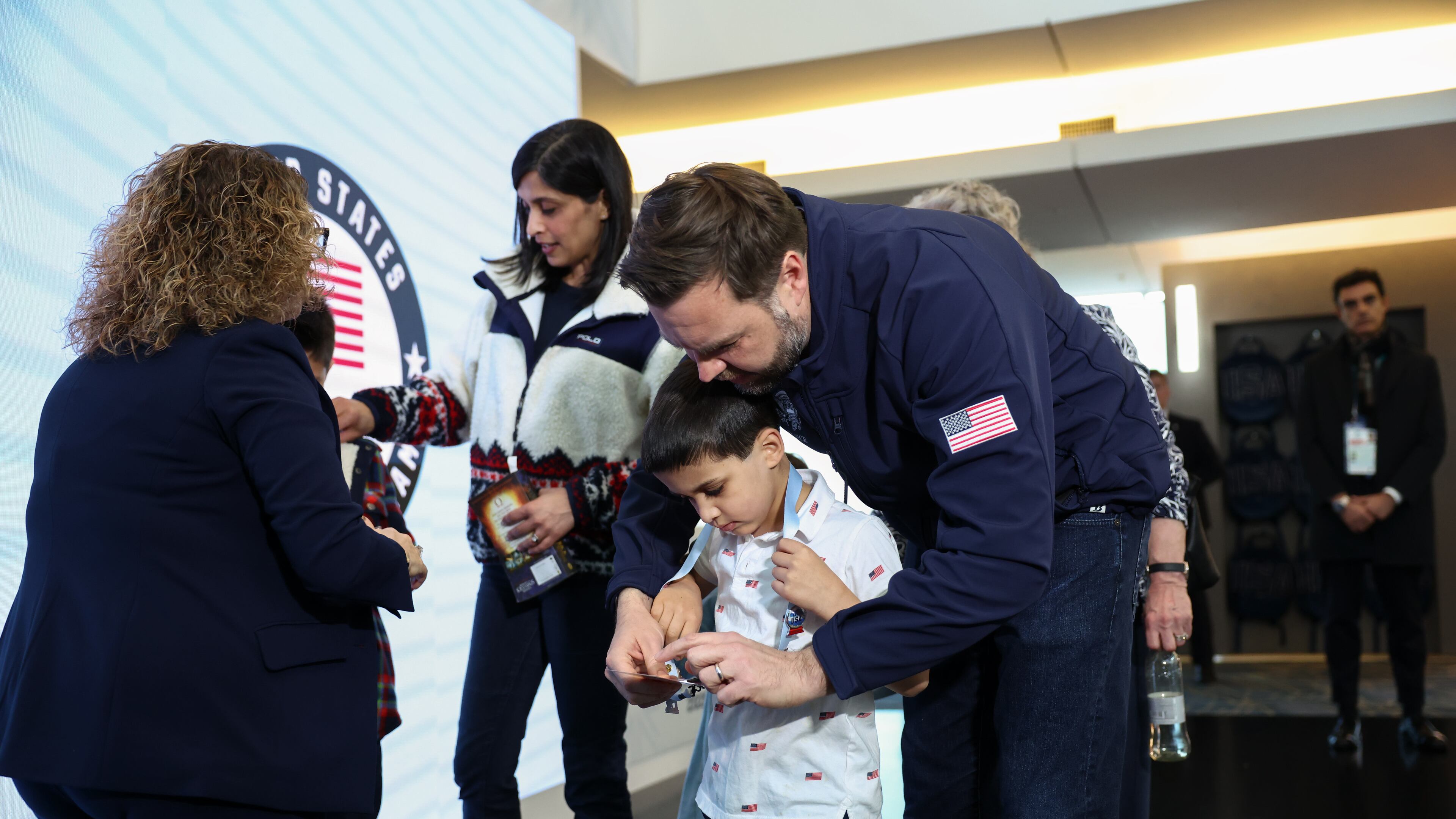 Vice President JD Vance holds his son Vivek's credentials, at the Team USA Welcome Experience, ahead of the Milano Cortina 2026 Winter Olympics in Milan, Italy, Thursday, Feb. 5, 2026. (Kevin Lamarque/Pool Photo via AP)