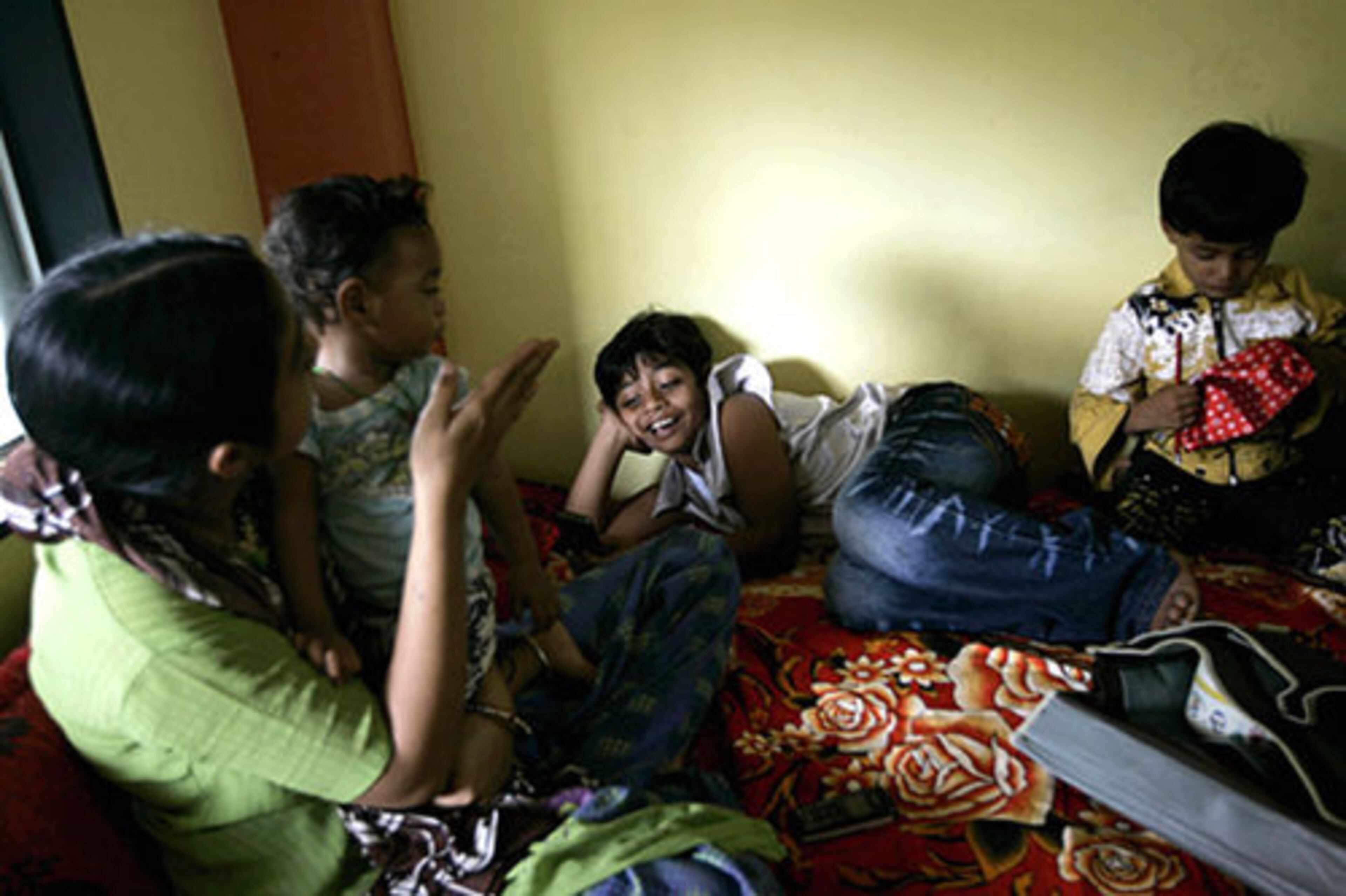 Azharuddin Mohammed Ismail, center, rests on a bed at his new home. Ismail and his mother moved into their new home on Saturday July 4, 2009.