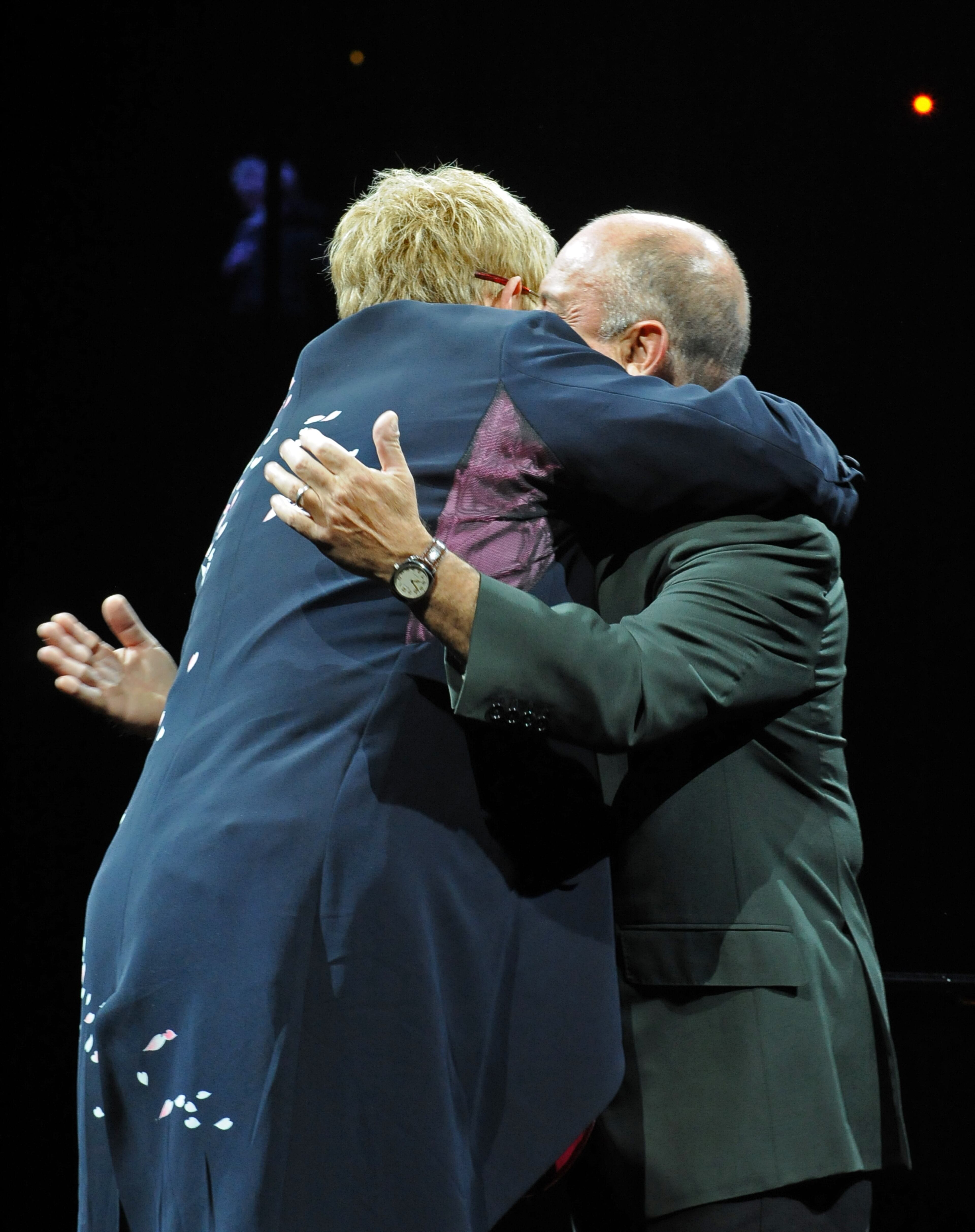 090314 Atlanta -- Elton John (left) and Billy Joel hug each other as they appear on the stage during the Face 2 Face tour Saturday night at Philips Arena. Elton John and Billy Joel, the most successful and longest-running concert pairing in pop history, reunite for their Face 2 Face tour beginning in March, 2009. John and Joel first toured together in 1994, and their most recent outing was a sold-out, 24-date trek in 2003. Elton and Billy open the concerts with a series of duets, playing twin pianos and trading vocals. Each artist then performs a set with his own band. Saturday, March 14, 2009 HYOSUB SHIN / hshin@ajc.com