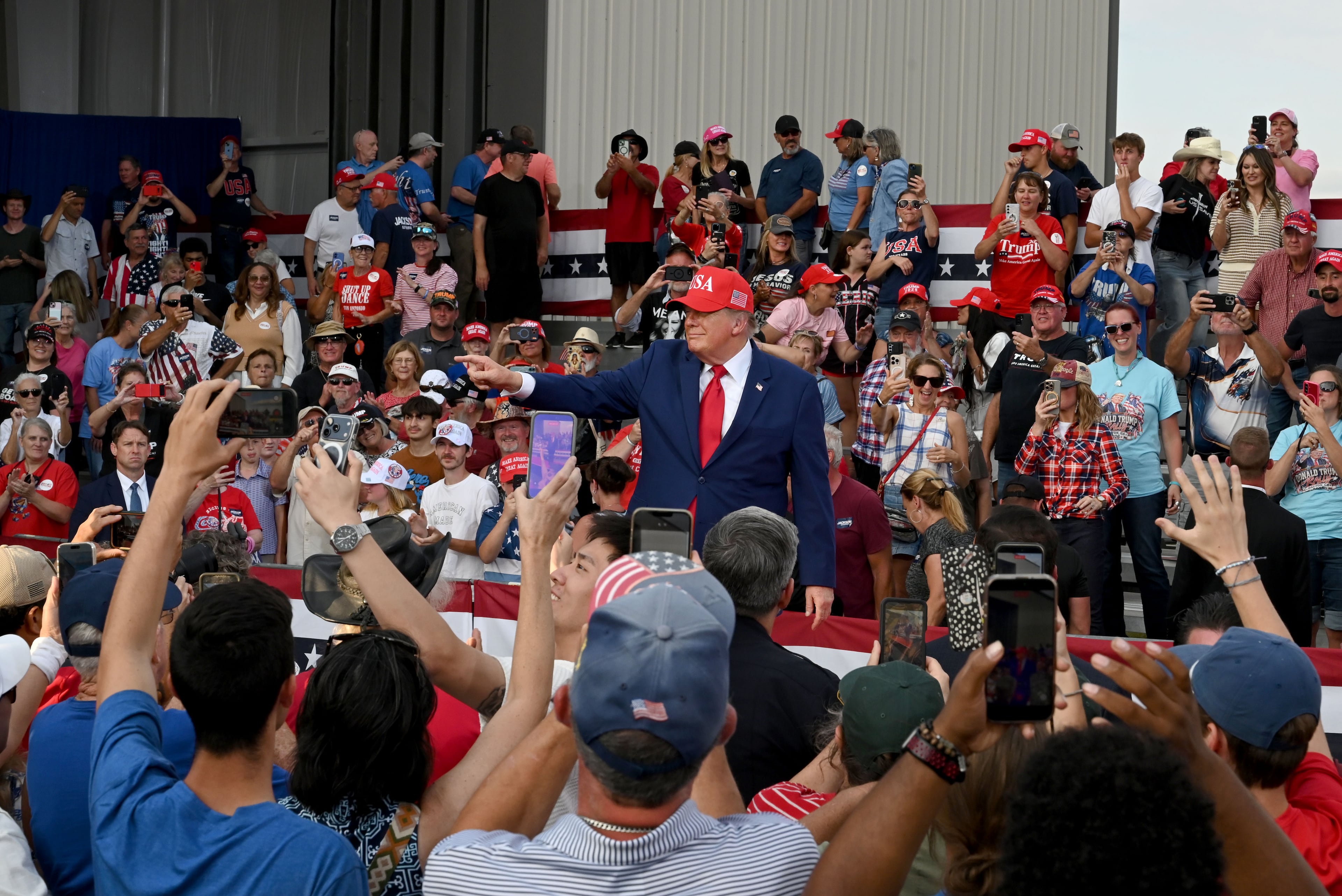 President Donald Trump (center) waves to supporters as he leaves the stage at the end of a campaign rally at Dalton Municipal Airport on Friday, Oct. 16, 2026, in Dalton. (Hyosub Shin/AJC)