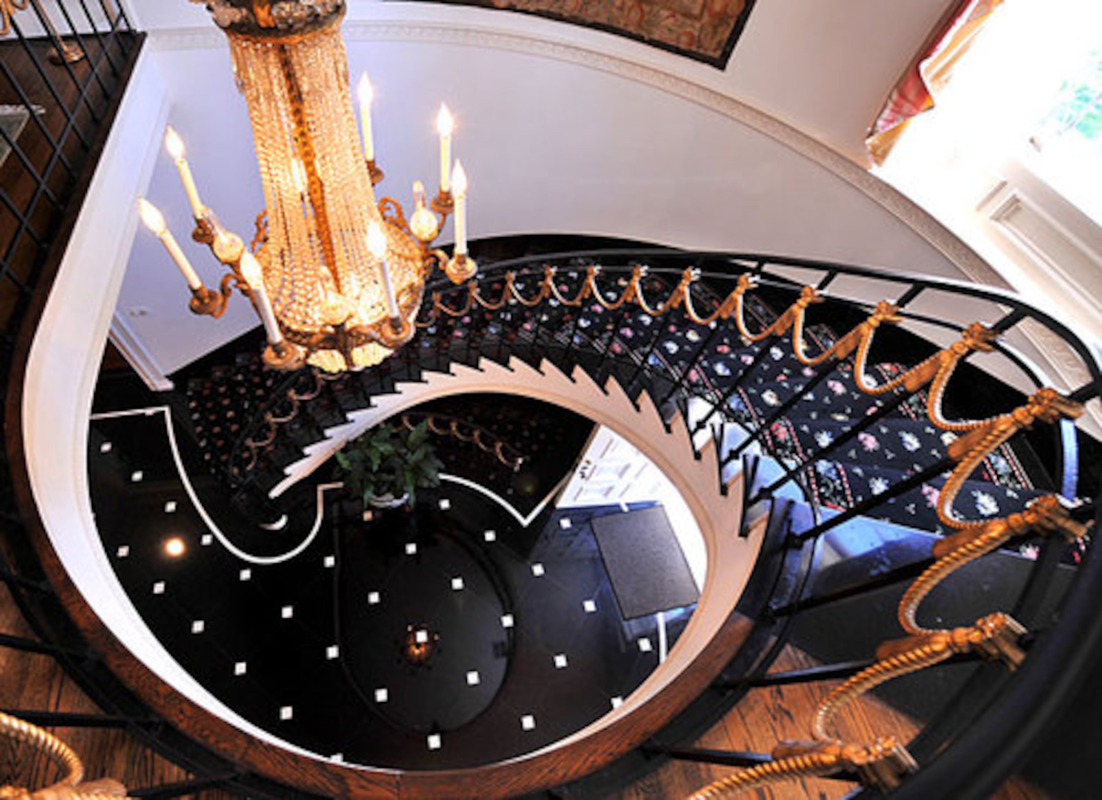 A dizzying view from the top of the spiral staircase looking down to the entry of the home.