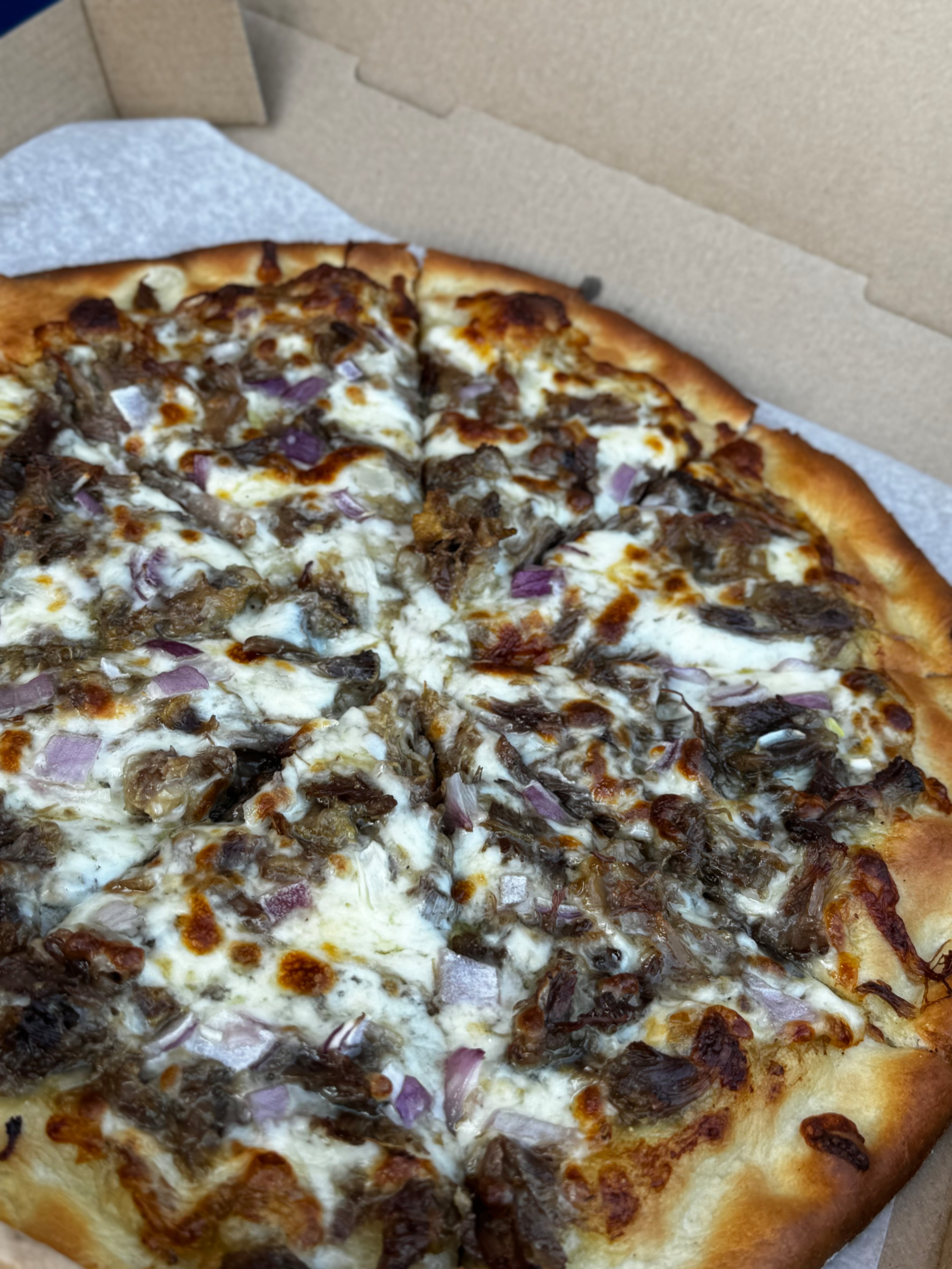 Union City’s 1804 Pizza Bar makes an oxtail pizza with slow-braised meat that’s shredded off the bone and spread out with a heavy ladle of peppery gravy that soaks right into the dough. (Justin Brown for the AJC)
