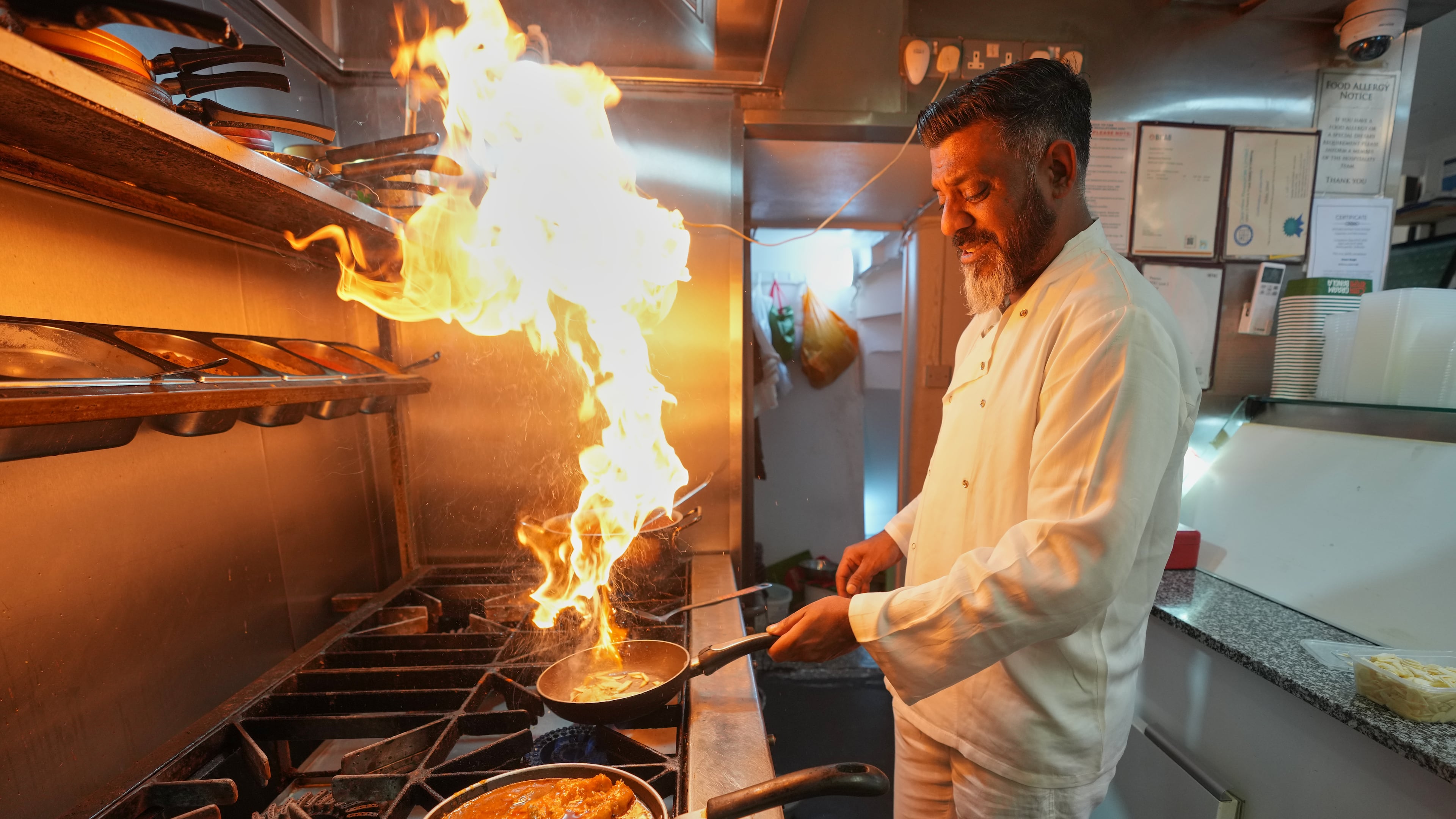 Chef Mohammed Shanoor Ali cooks at a Bangladeshi restaurant in London, Thursday, June 18, 2026. (AP Photo/Kin Cheung)