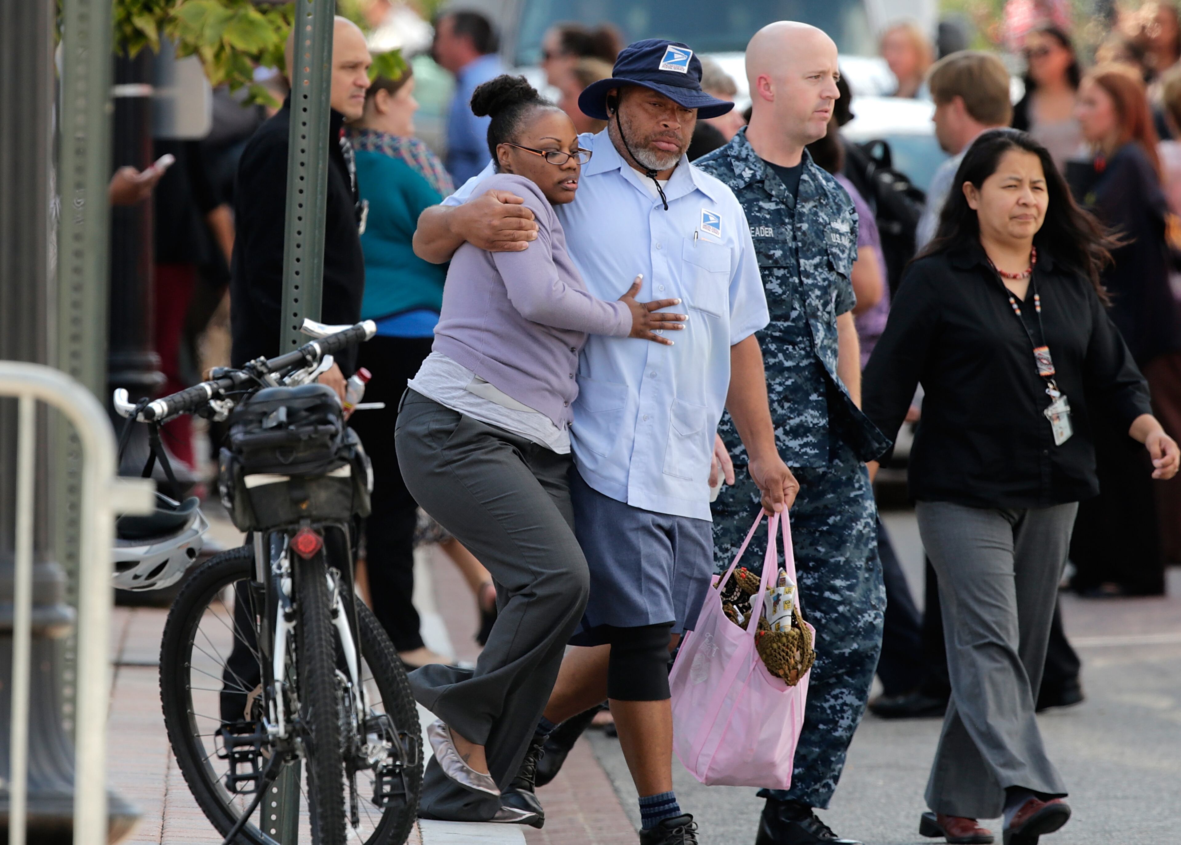 After a bus dropped off employees recently released from the Navy Yard complex, a couple walks away from a gathering point for families that was set up inside Nationals Park in the wake of the Navy Yard shooting Sept. 16, 2013, in Washington, D.C.