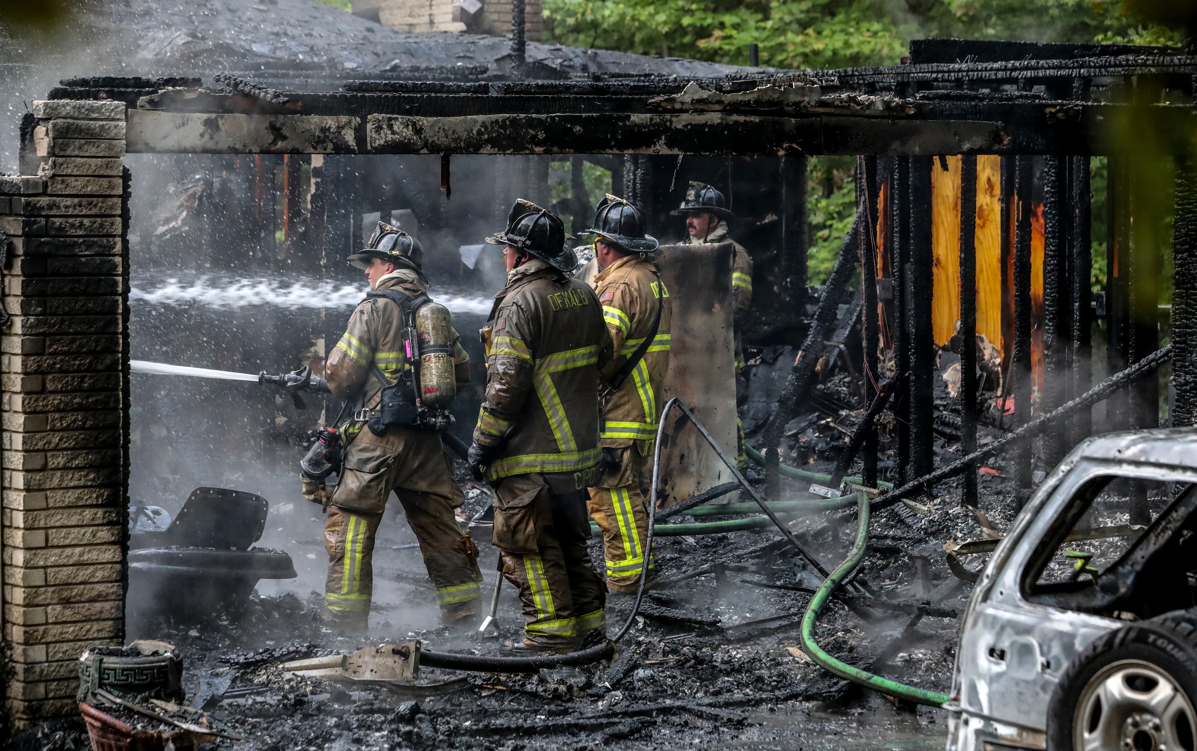 Three DeKalb County firefighters had just gotten through the door of a burning house in Tucker when they were pushed out by the flames early Thursday morning, May 4, 2023. When crews arrived at the house on Oxbow Road just before 6 a.m., they found heavy flames coming from the garage, DeKalb fire spokesperson Capt. Jaeson Daniels told reporters at the scene. By that point, the residents had made it out safely, he said. The three firefighters suffered moderate burns and were taken to Grady Memorial Hospital, officials said. (John Spink / John.Spink@ajc.com)