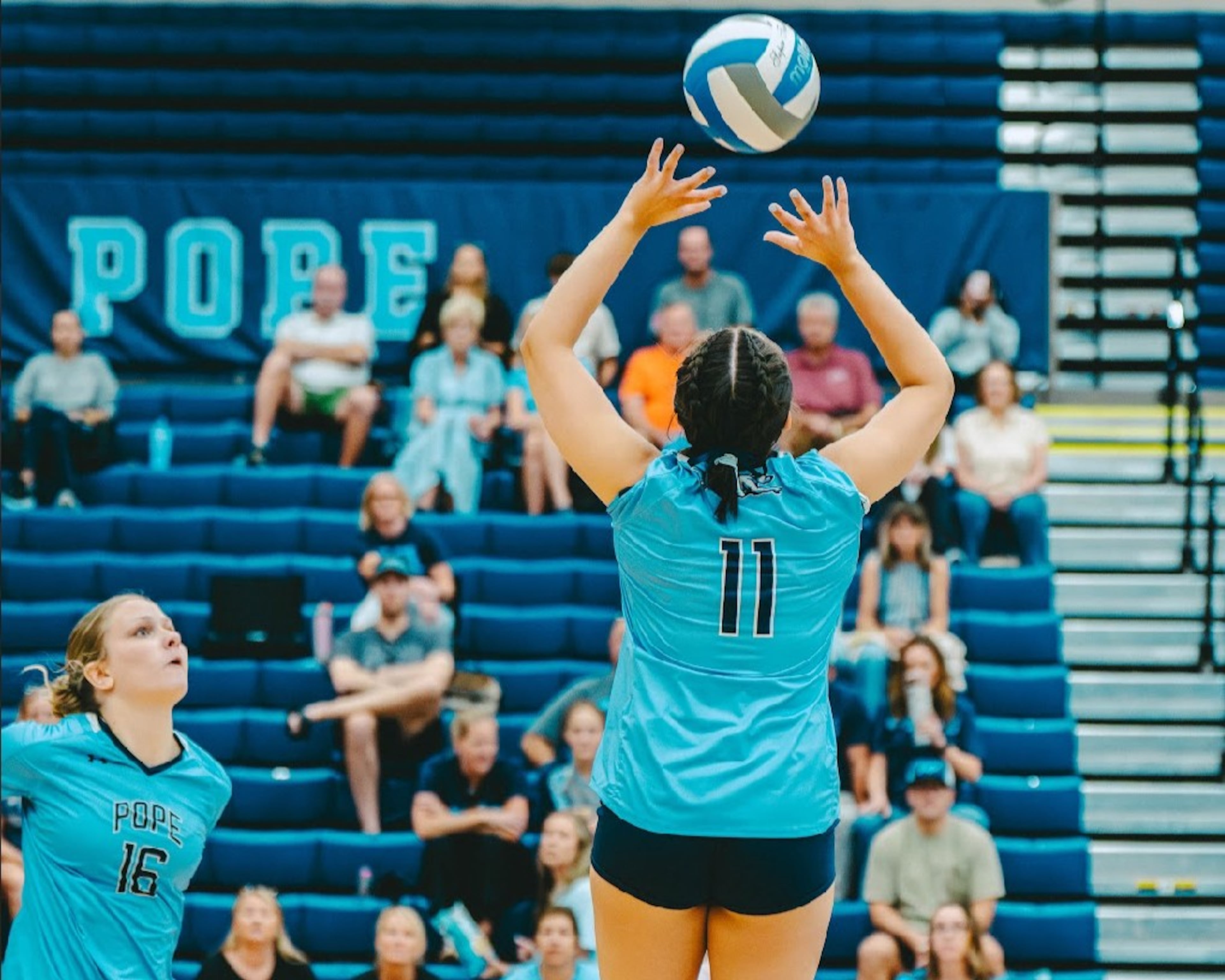 Jahan Lalli (center) sets up a shot for teammate Gretchen Eichelzer in one of Pope High School's matches in 2025. (Courtesy of Pope High School)